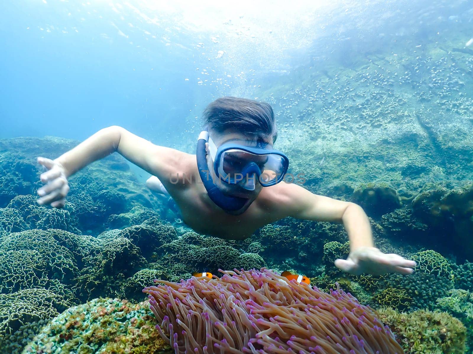 young men at a snorkeling trip in Samaesan Thailand dive underwater with fishes in the coral reef sea pool. Travel lifestyle, watersport adventure, swim activity on a summer beach holiday