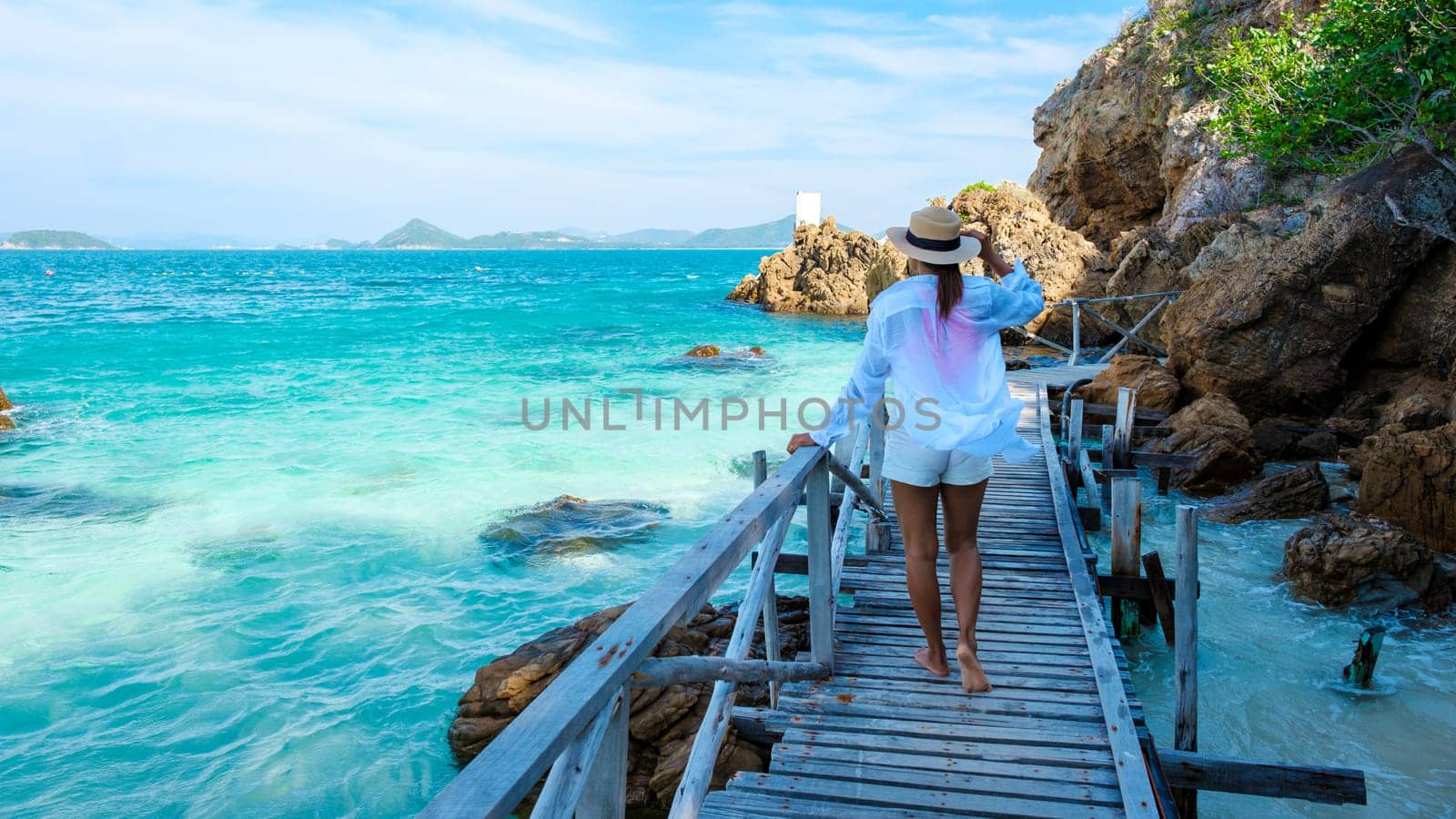 Asian woman on a day trip to Ko Kham Island Sattahip Chonburi Samaesan Thailand a tropical Island in Thailand with a blue ocean, woman at the beach of a tropical island