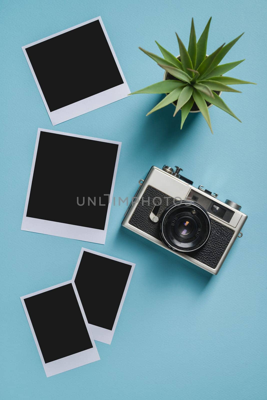Vintage photo camera and empty photo frames on blue background. Travel moment concept by Sonat