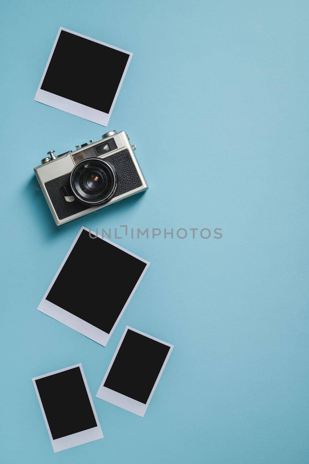 Vintage photo camera and empty photo frames on blue background. Travel moment concept