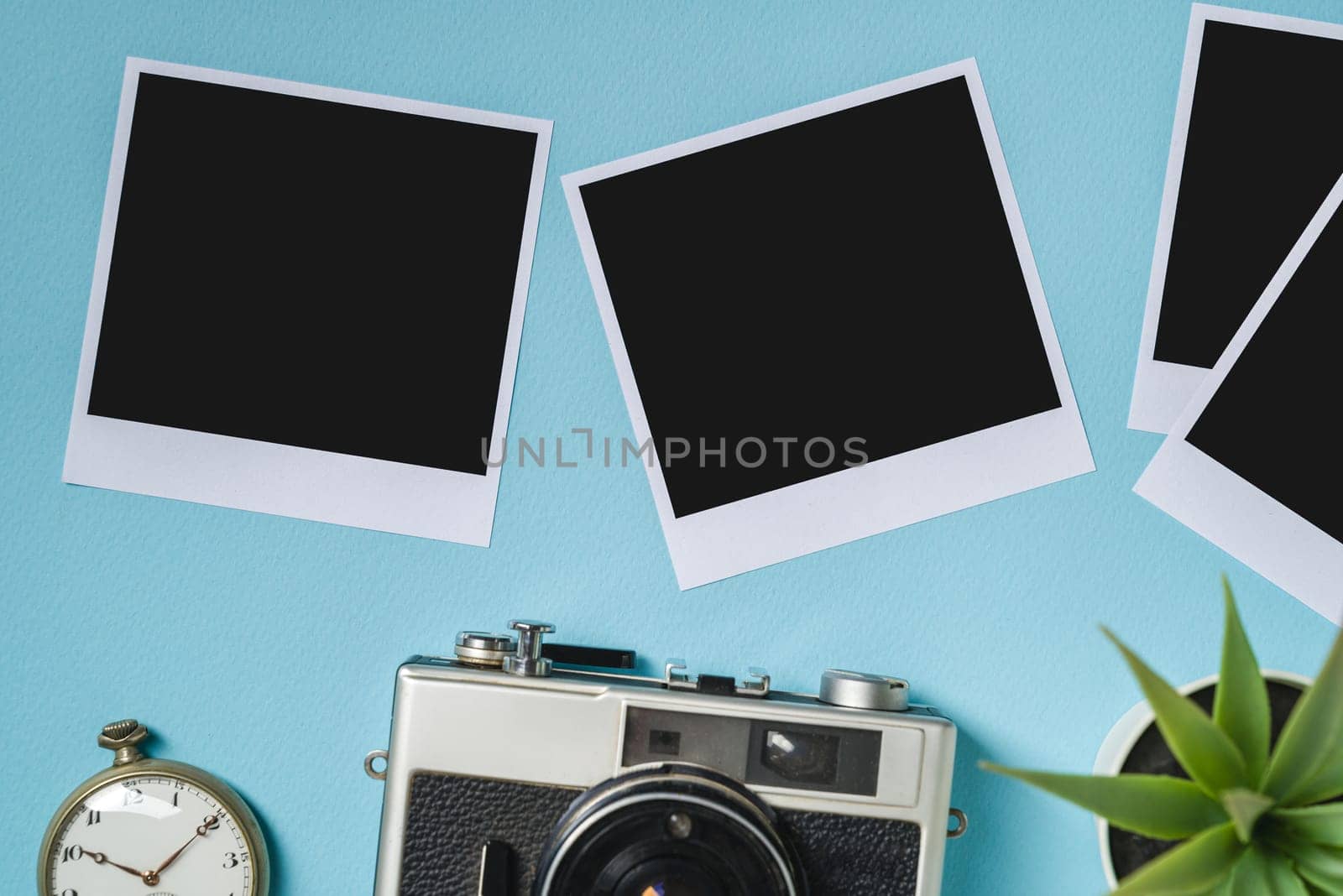 Vintage photo camera and empty photo frames on blue background. Travel moment concept