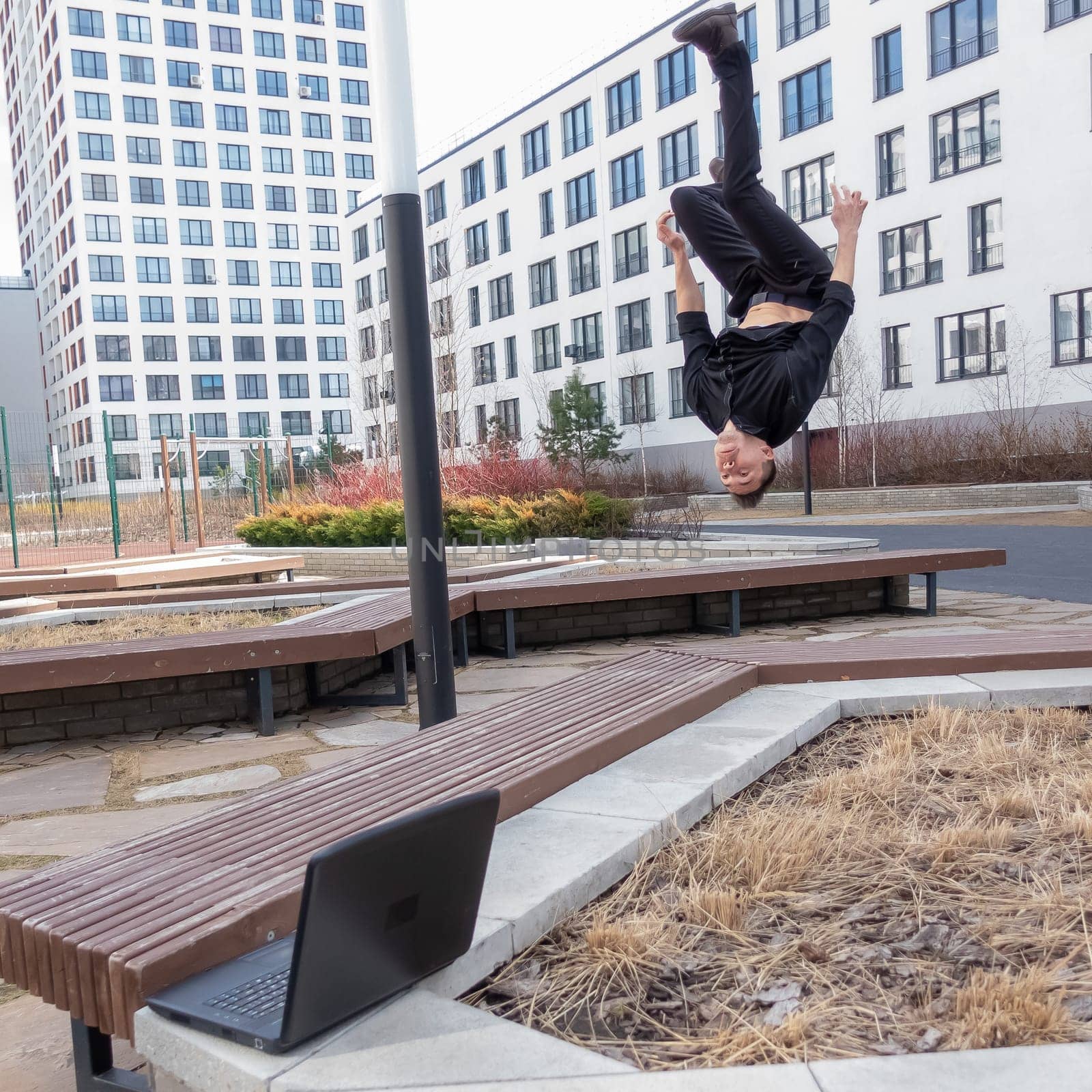 A man types on a laptop outdoors and then does a somersault. by mrwed54