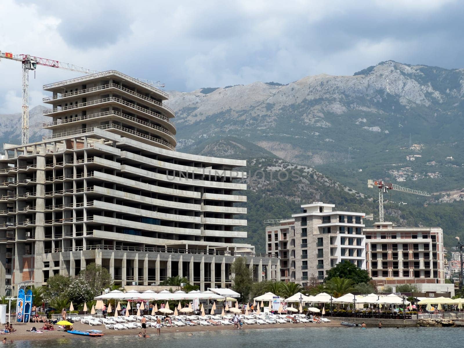 Budva, Montenegro - 08 august 2023: Construction of high-rise hotels near the beach by the sea by Nadtochiy