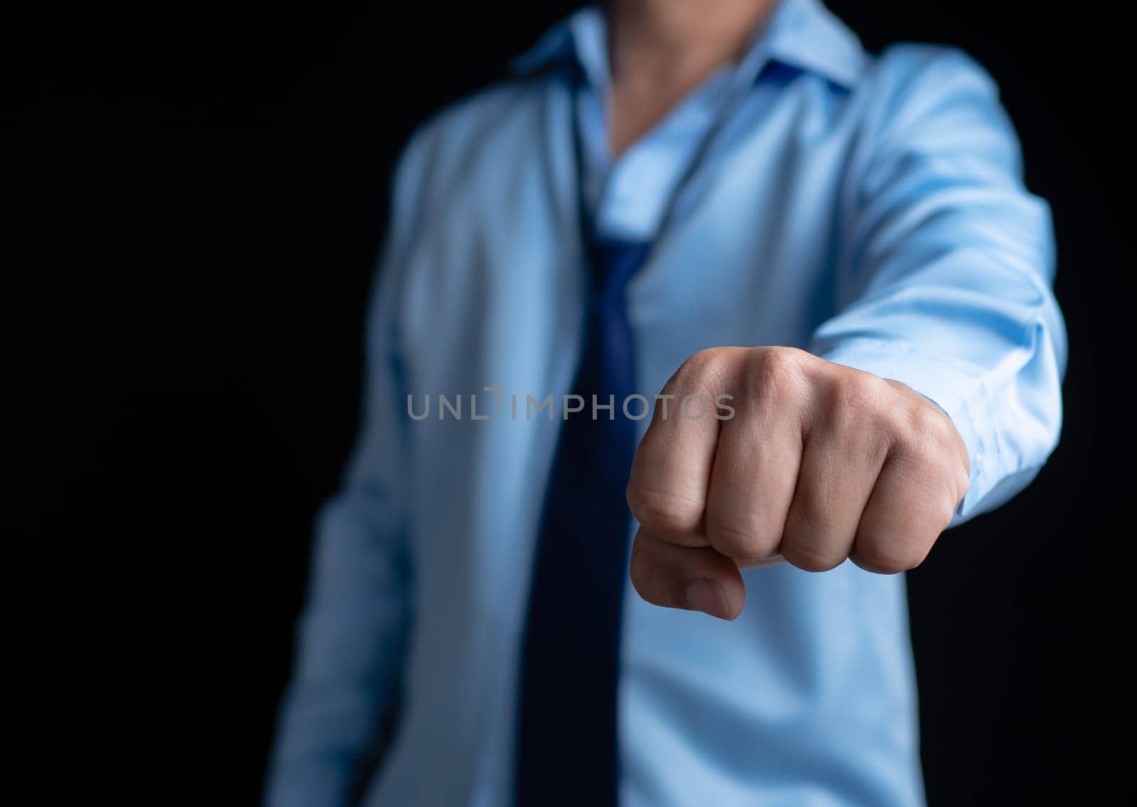 Businessman shows his fists in a fighting stance showing determination. Ready to fight against business competitors.