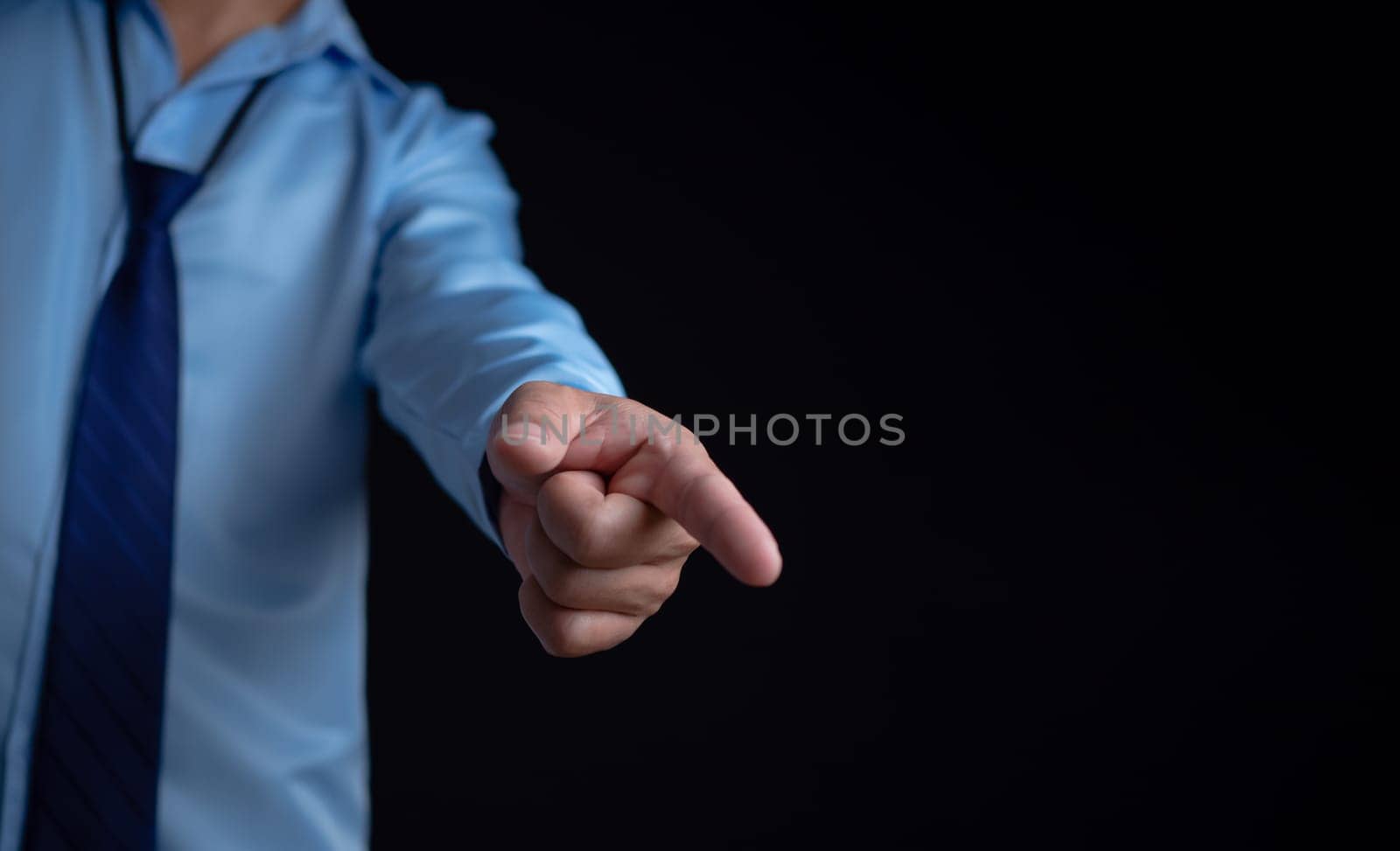 Employee makes a forward pointing gesture on a dark background.
