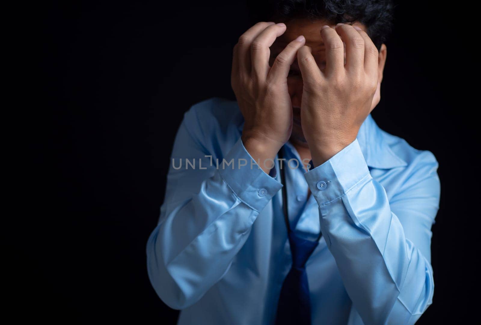 Businessman acted tired headache stressed and anxious from the frustrated business crisis, expresses disappointment, regret, making a mistake. by Unimages2527