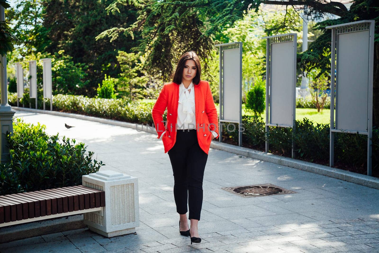 Beautiful woman in red business suit outdoors by Simakov
