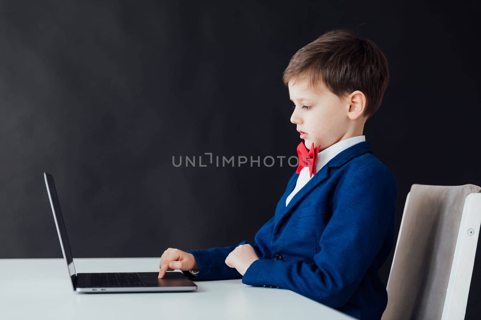 boy in jacket working online at computer