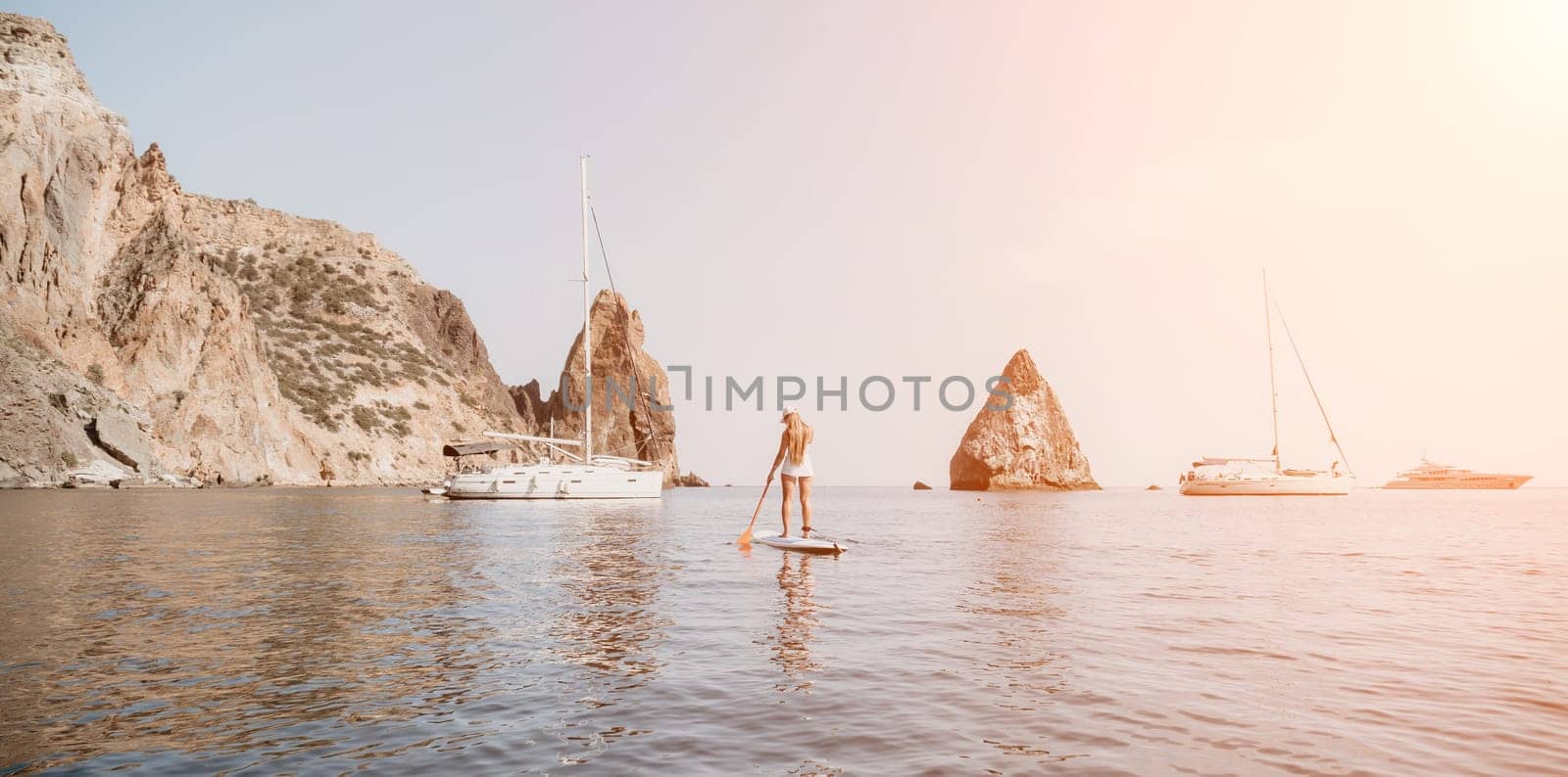 Woman sea sup. Close up portrait of happy young caucasian woman with long hair looking at camera and smiling. Cute woman portrait in bikini posing on sup board in the sea by panophotograph