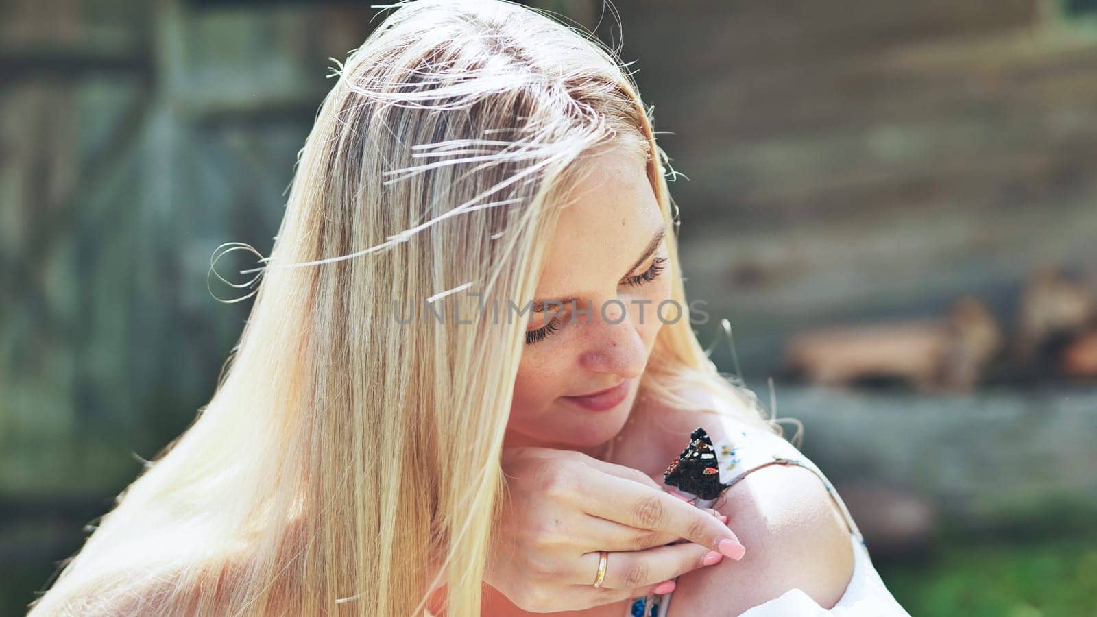 The girl gently enjoys the butterfly that flew to her