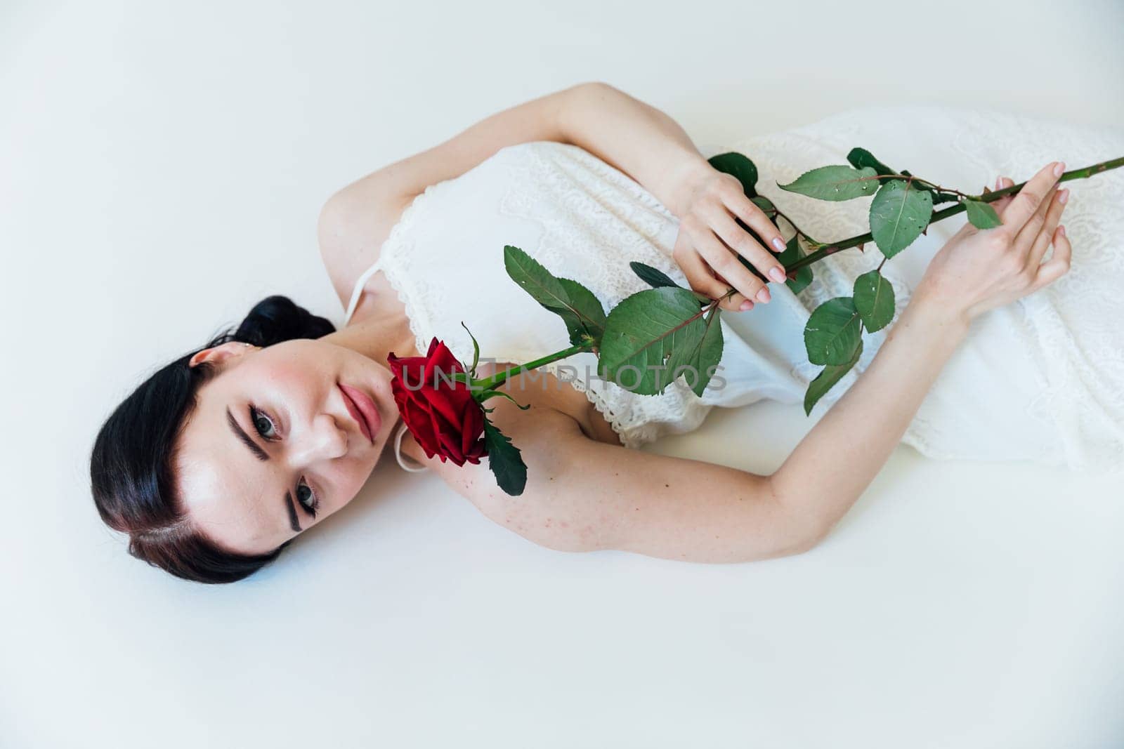 Beautiful young brunette woman with red rose by Simakov