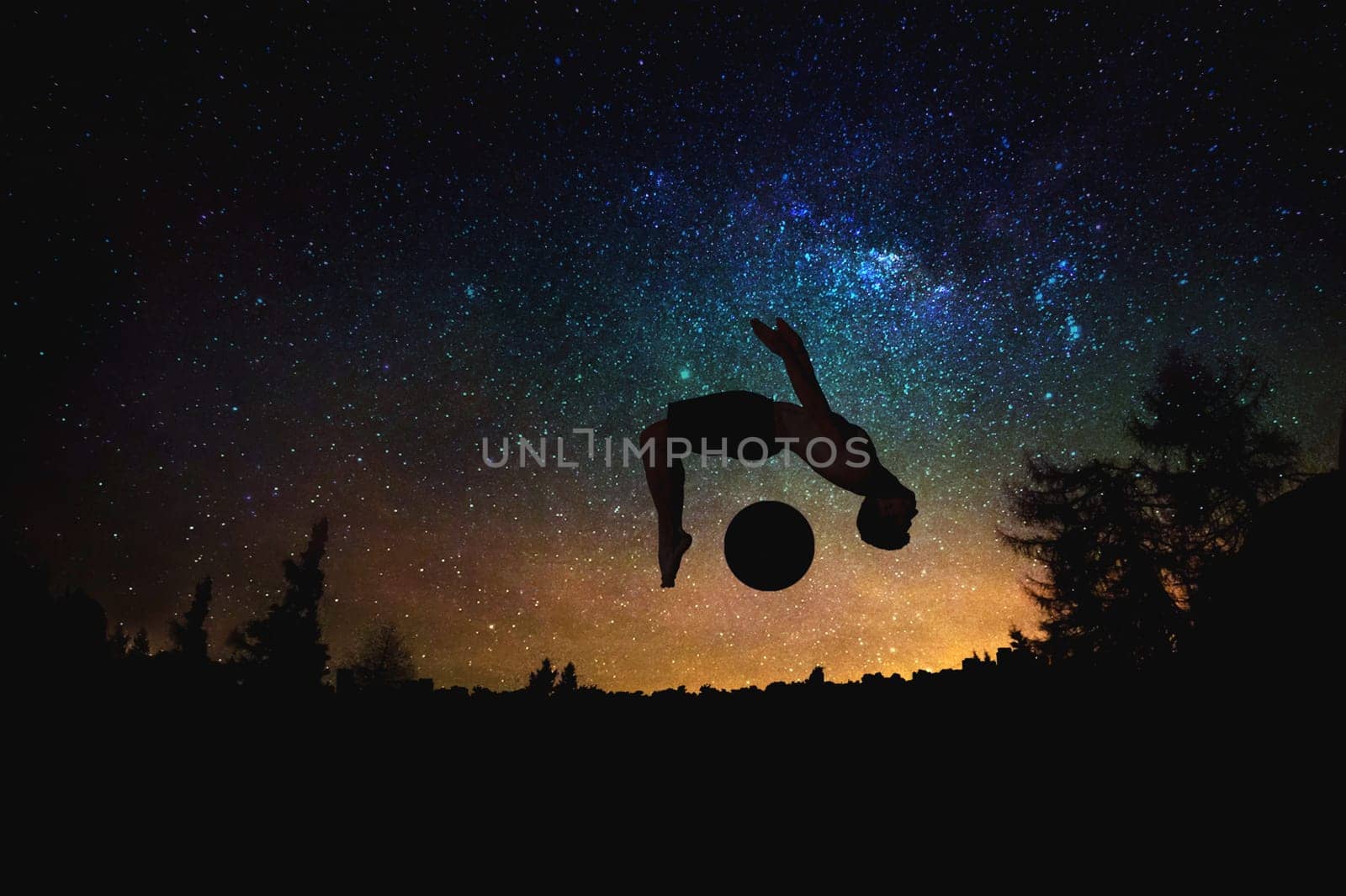 sporty man jumping silhouette at the night starry sky and moon background. by nazarovsergey