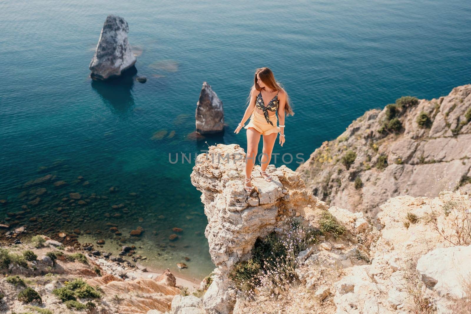 Woman travel sea. Happy tourist enjoy taking picture outdoors for memories. Woman traveler looks at the edge of the cliff on the sea bay of mountains, sharing travel adventure journey by panophotograph