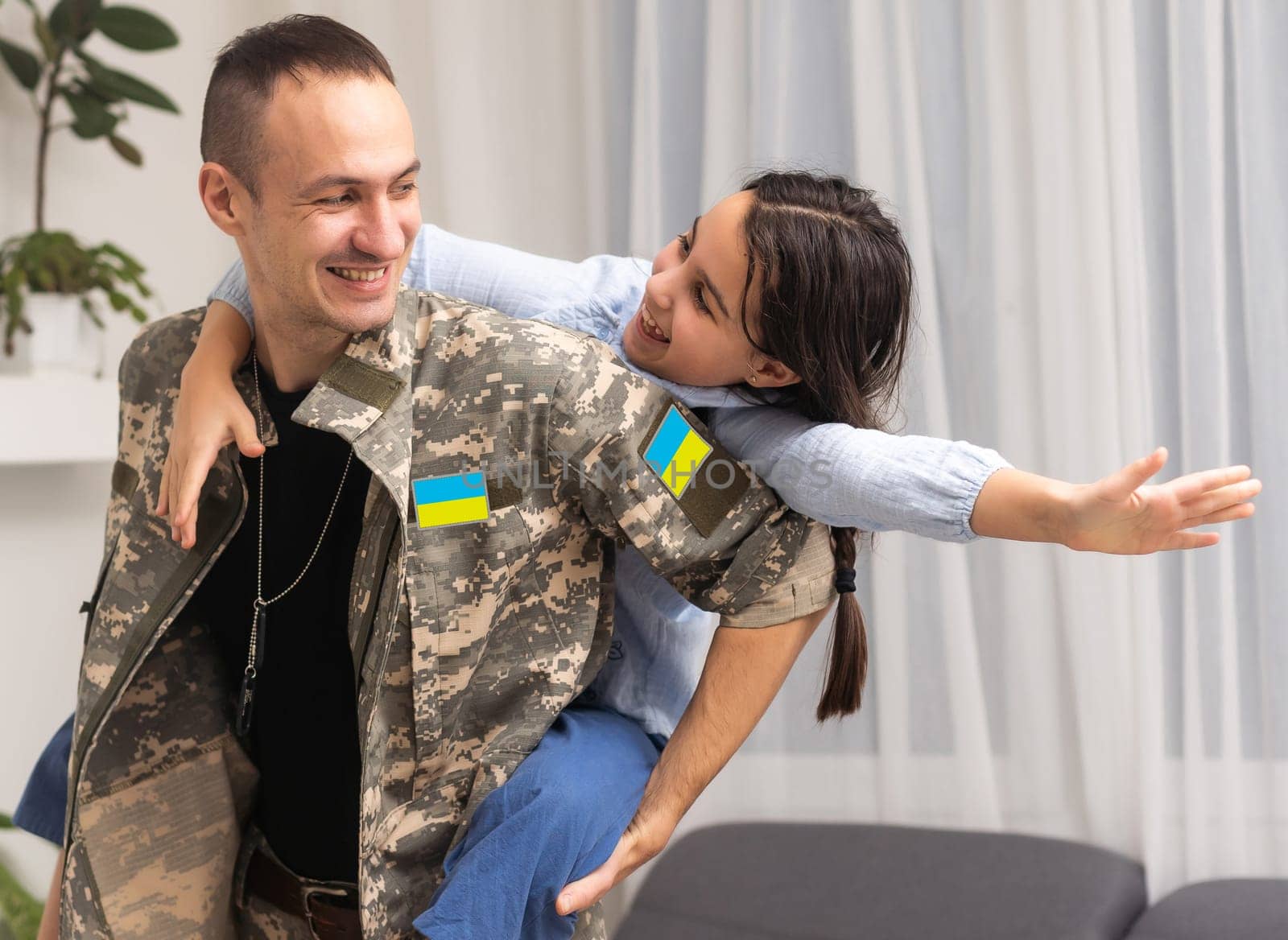 Father in Ukrainian military uniform and his daughter. Family reunion.