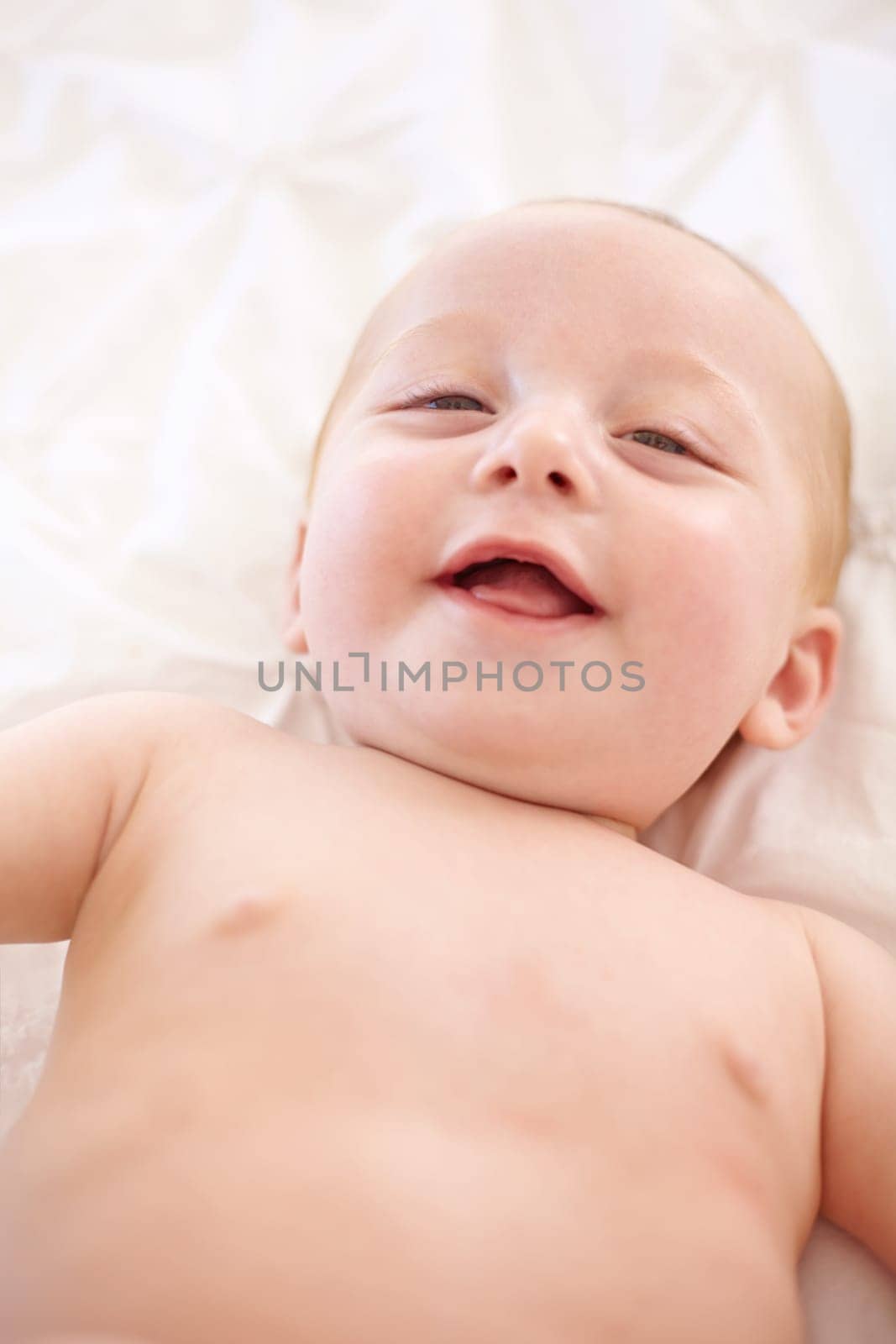 Happy baby on bed, funny and top view portrait of young child in development, excited or relax at home. Face, above and infant kid laugh in nursery, rest in bedroom or healthy body, cute or adorable.