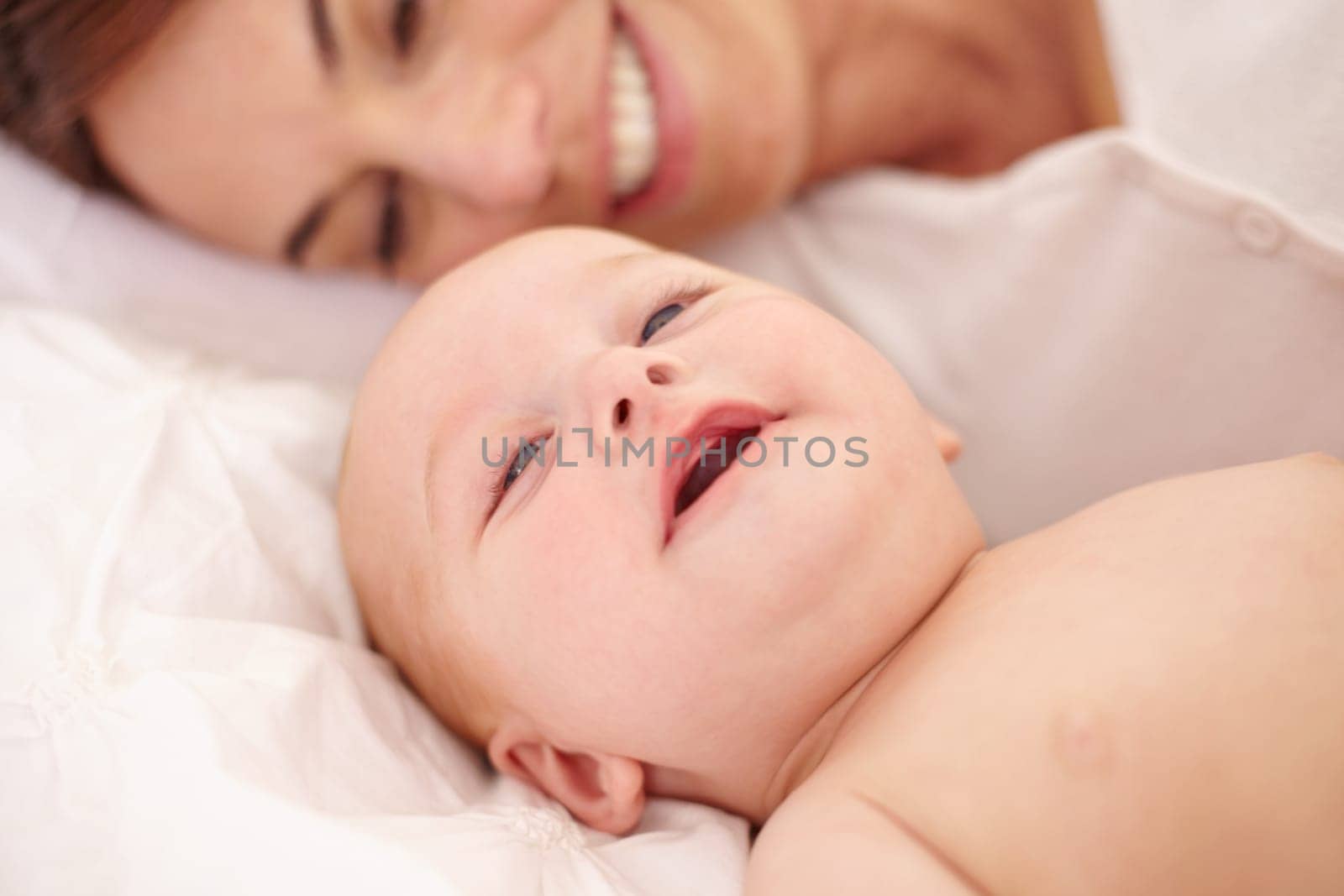 Mother, baby and happiness or love, care and relaxing on bed, bonding and joy in parenthood. Mom, newborn and peace or calm at home, positive and happy for child development, smile and rest together.