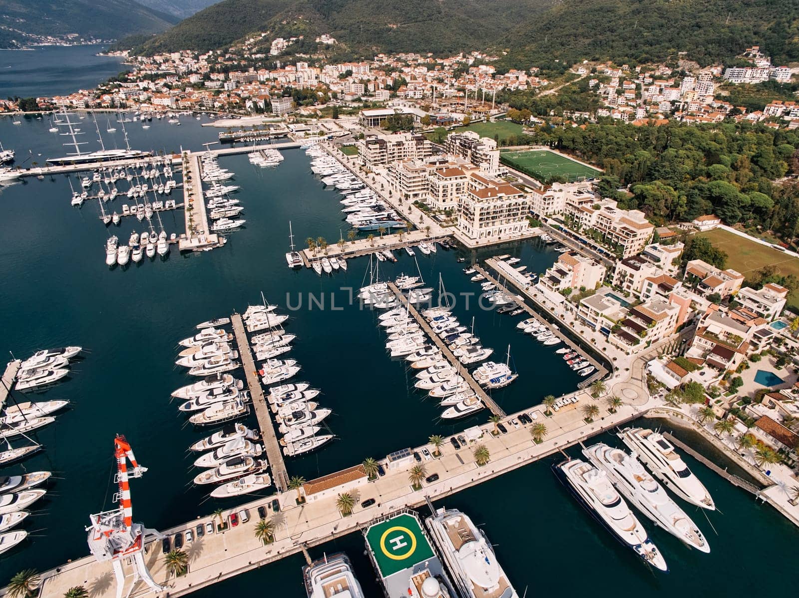 Rows of yachts along several marina piers. Porto, Montenegro. Top view. High quality photo