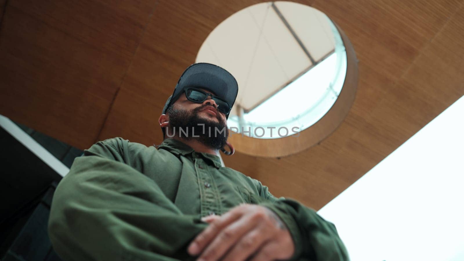 Motion shot of asian handsome hipster pose in hip hop style while looking at camera. Low angle image of professional street dancer dance in freestyle movement at mall. Outdoor sport 2024. Endeavor.