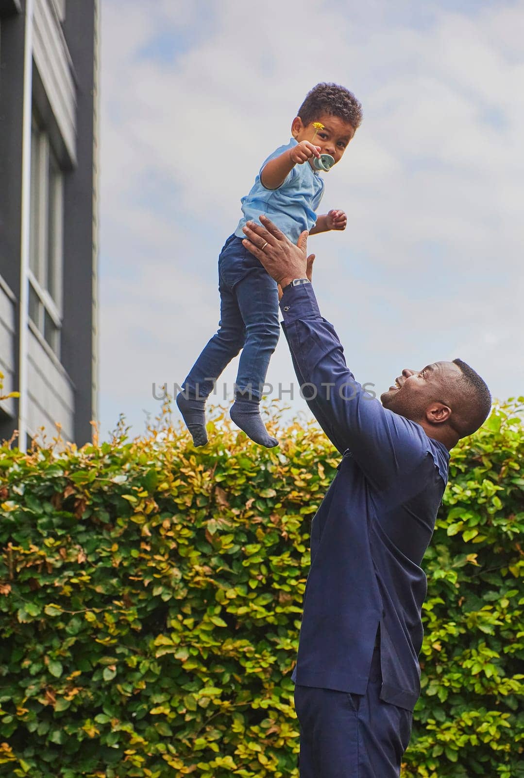 Tilst, Denmark, 12th of August: Father playing with son in the yard.