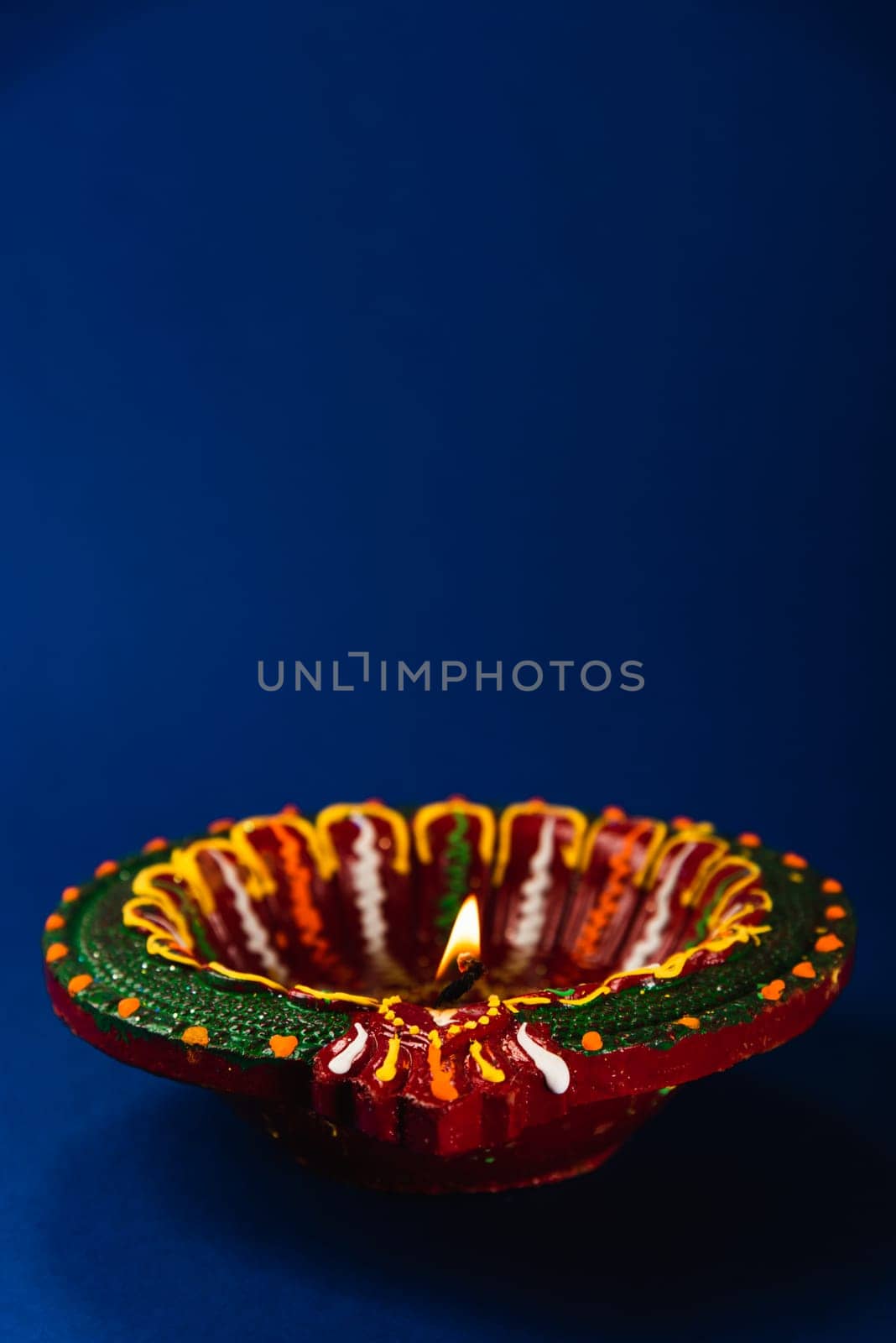 Celebrate Diwali with these shining clay diya lamps, symbols of prosperity and happiness, radiating warmth on a blue background. Perfect for invitations, religious-themed art, and text overlays. by Sorapop