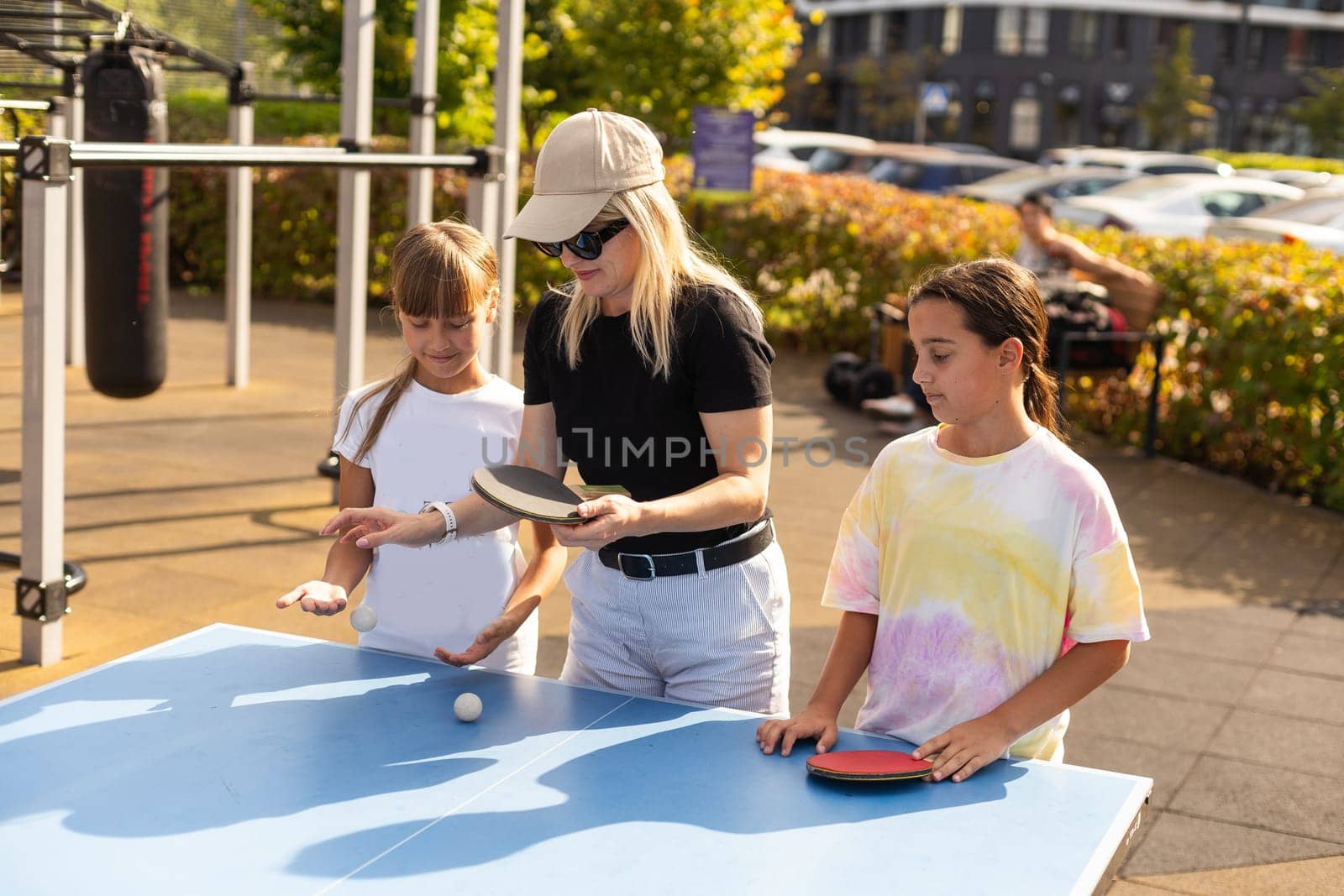 Cute girls playing ping-pong indoors. High quality photo