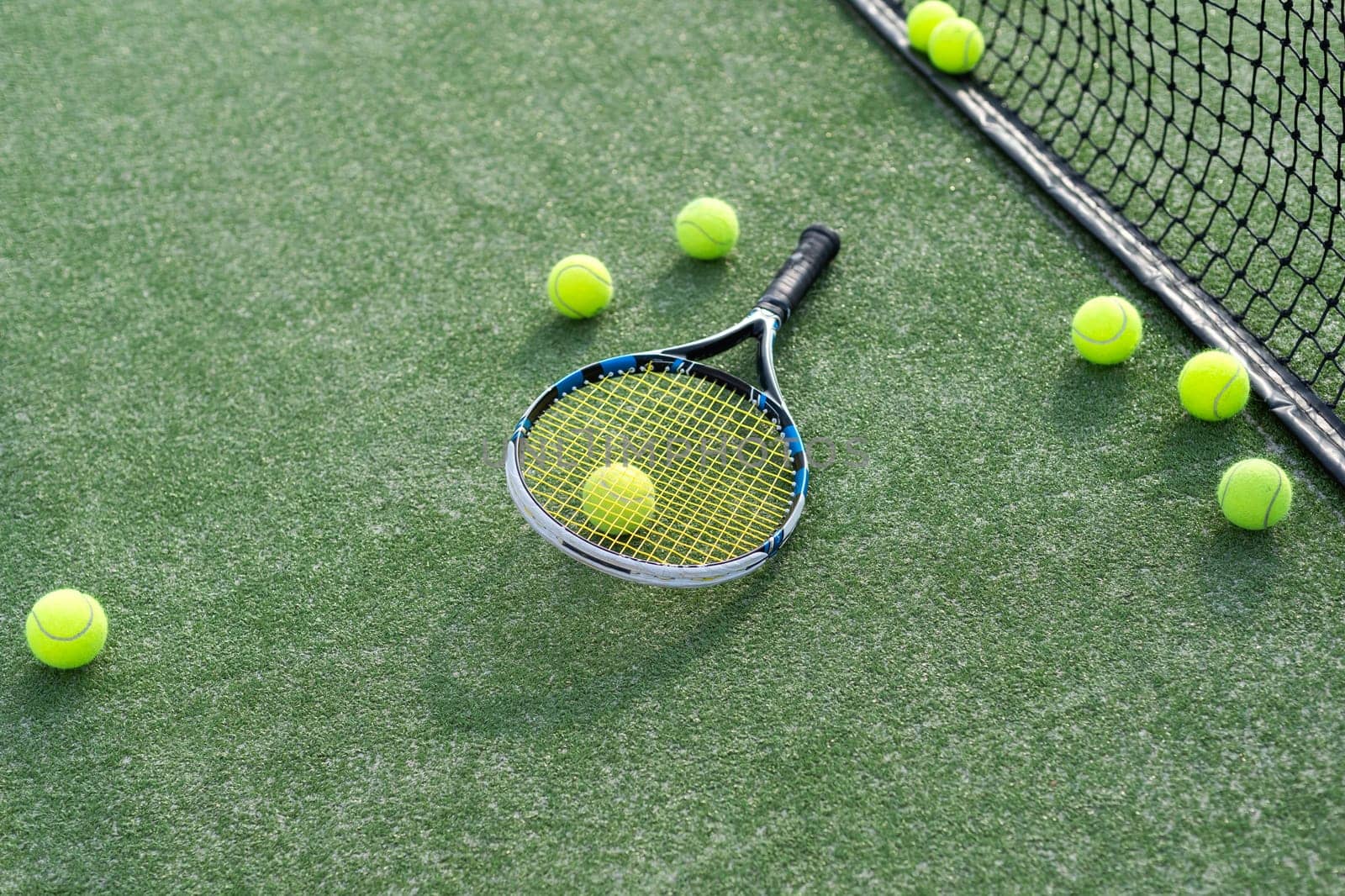 High angle view of tennis racket and ball by marking on grassy land at tennis court. Copy space, unaltered, sport, competition, green, nature and summer concept. High quality photo