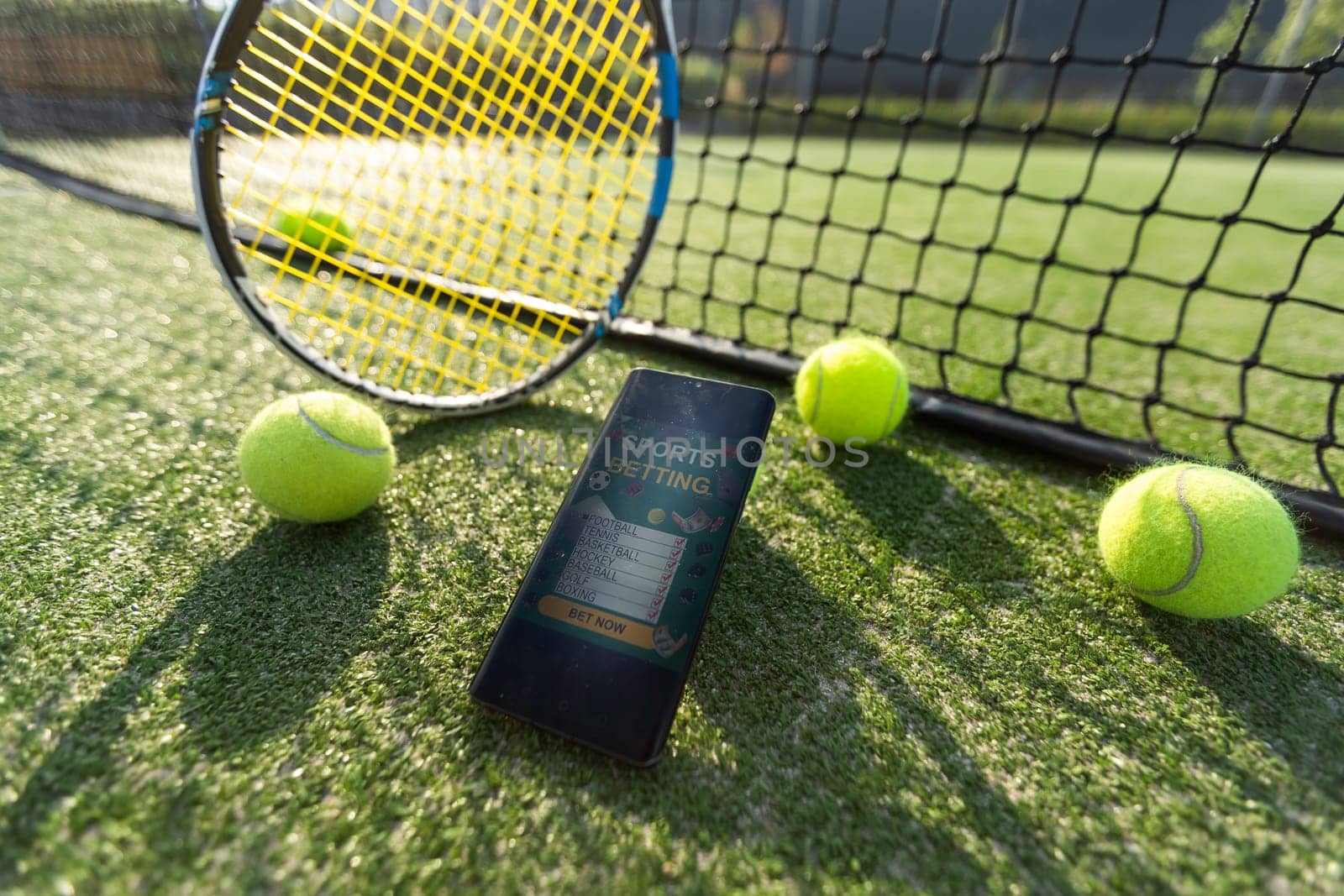 High angle view of mobile phone with tennis equipment on black background. High quality photo