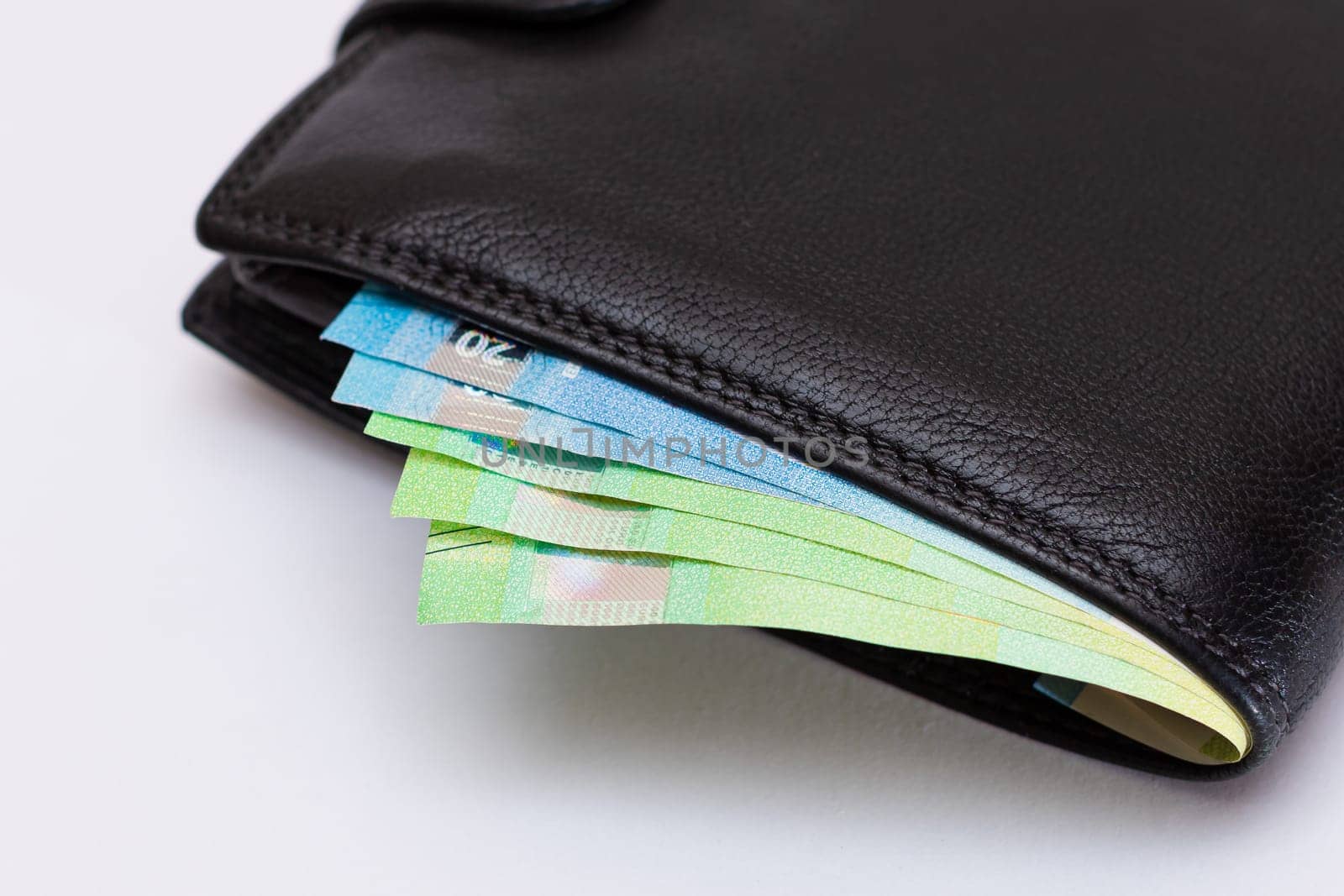 Black Leather Men Wallet with Euro Banknotes Inside on White Background. A Purse Full of Money Symbolizing Wealth, Success and Social Status
