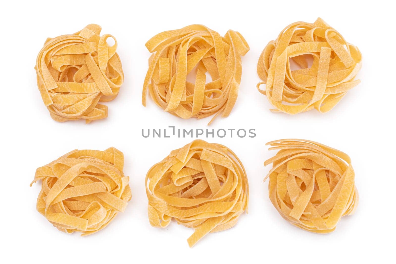 Six Classic Italian Raw Egg Fettuccine - Isolated on White Background. Dry Twisted Uncooked Pasta. Italian Culture and Cuisine. Raw Golden Macaroni Pattern - Isolation