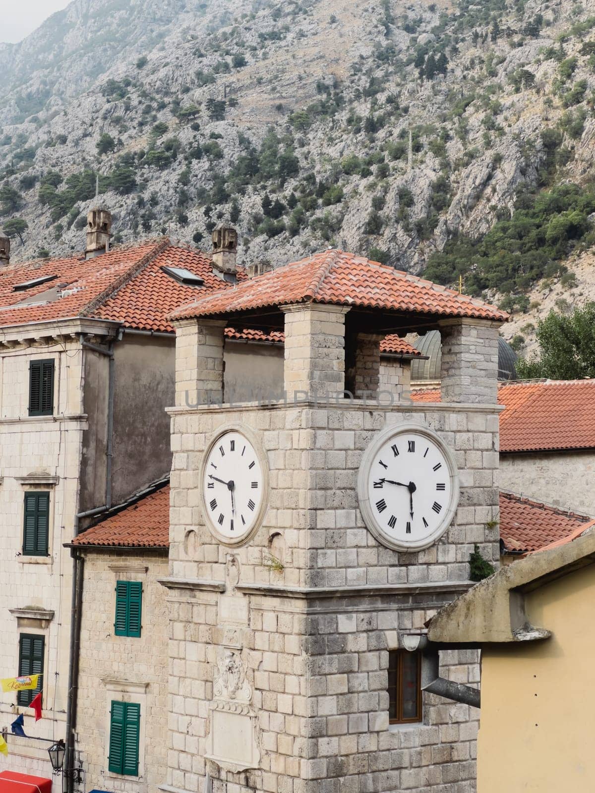 Kotor, Montenegro - 06 august 2023: Ancient stone clock tower. Kotor, Montenegro by Nadtochiy