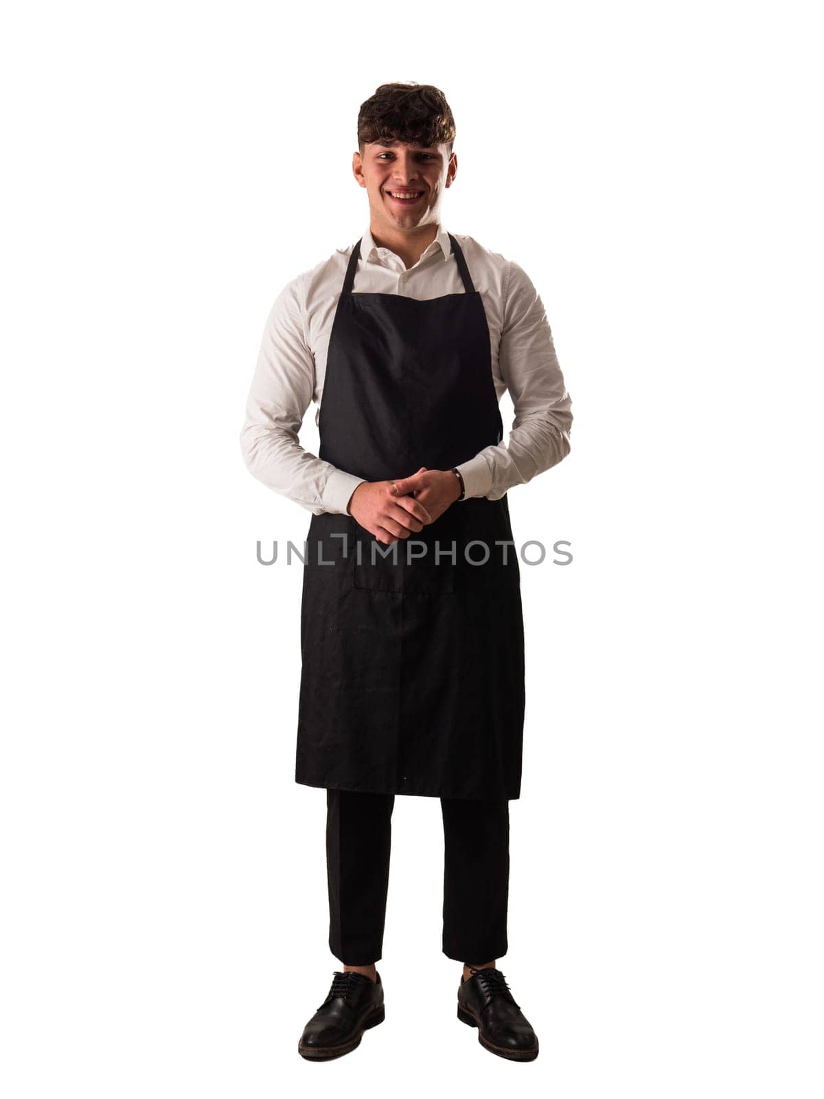 Full length shot of young chef or waiter posing, wearing black apron and white shirt by artofphoto