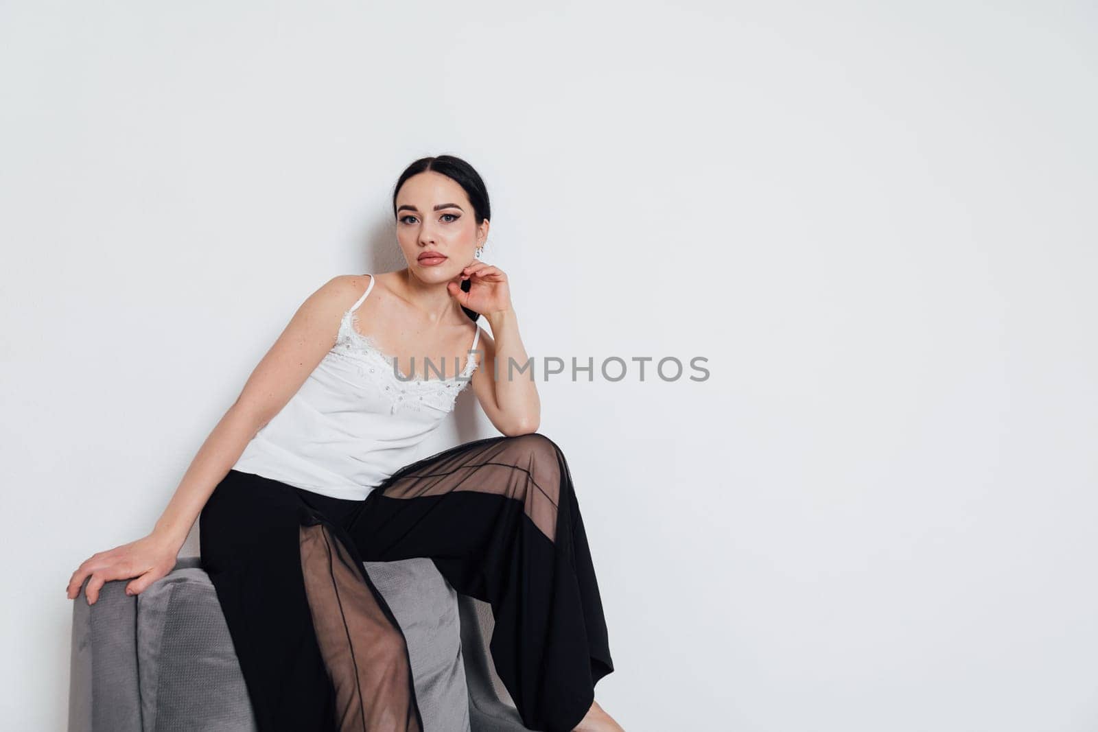Beautiful fashionable woman posing in studio by Simakov
