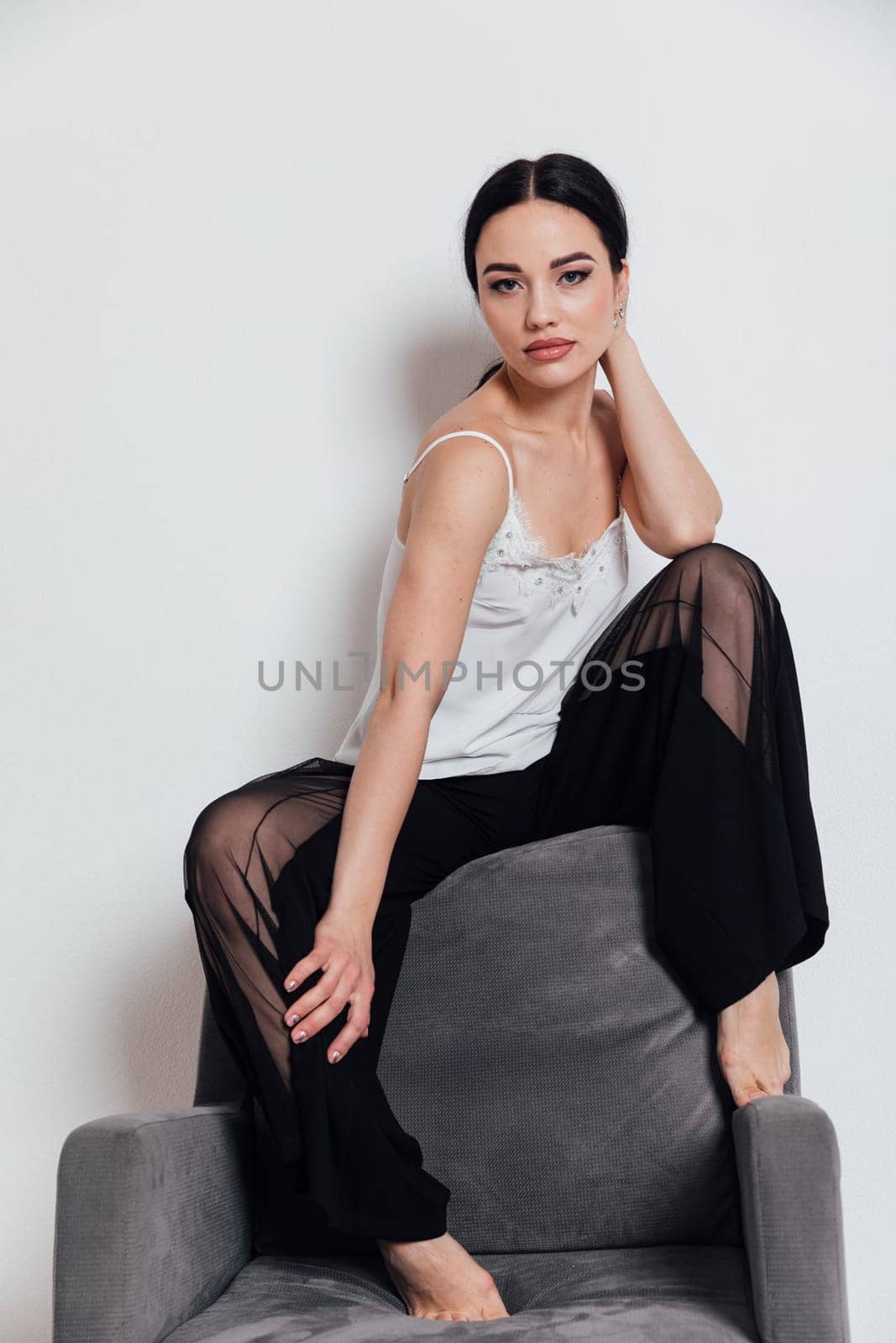 Beautiful fashionable woman posing in studio by Simakov