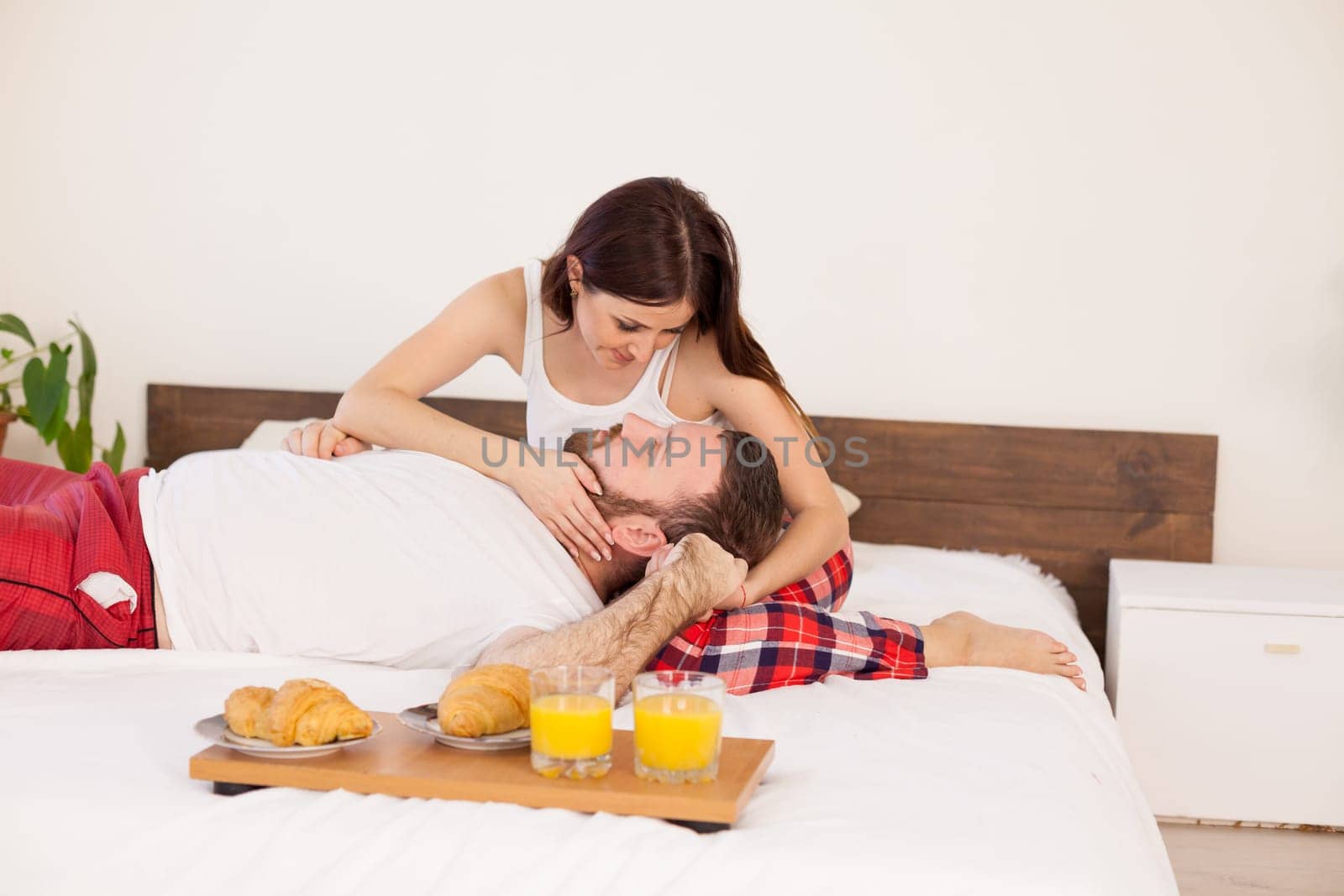 a man and a woman in the morning breakfast in bed by Simakov