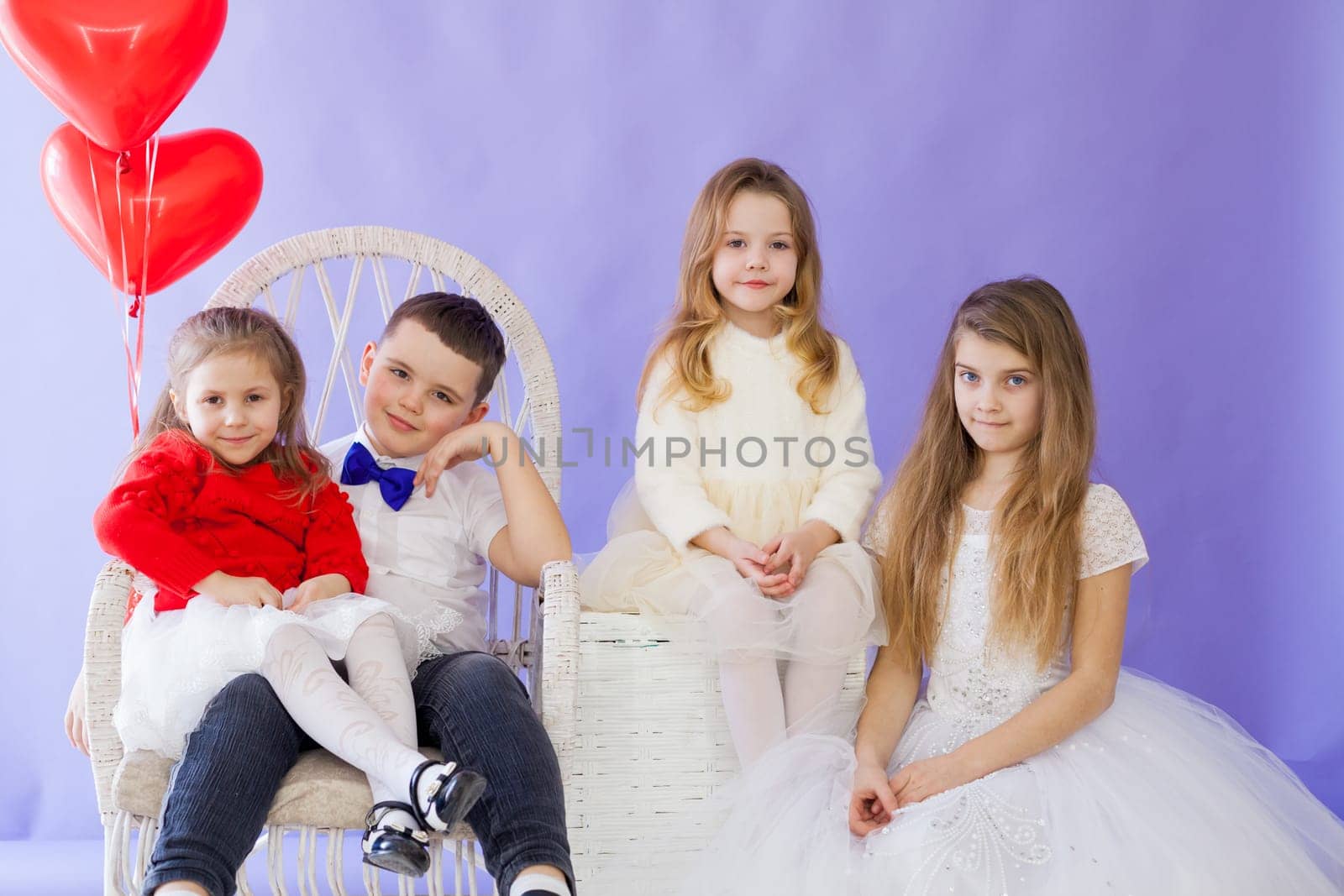 girls and boy with red balloons in the shape of a heart