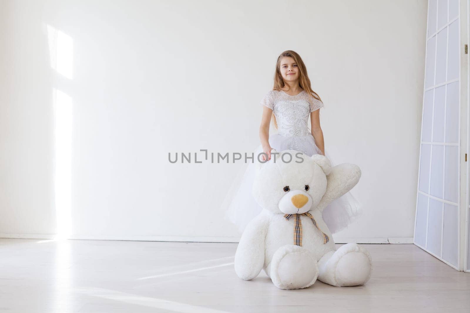 girl holds a large soft toy polar bear