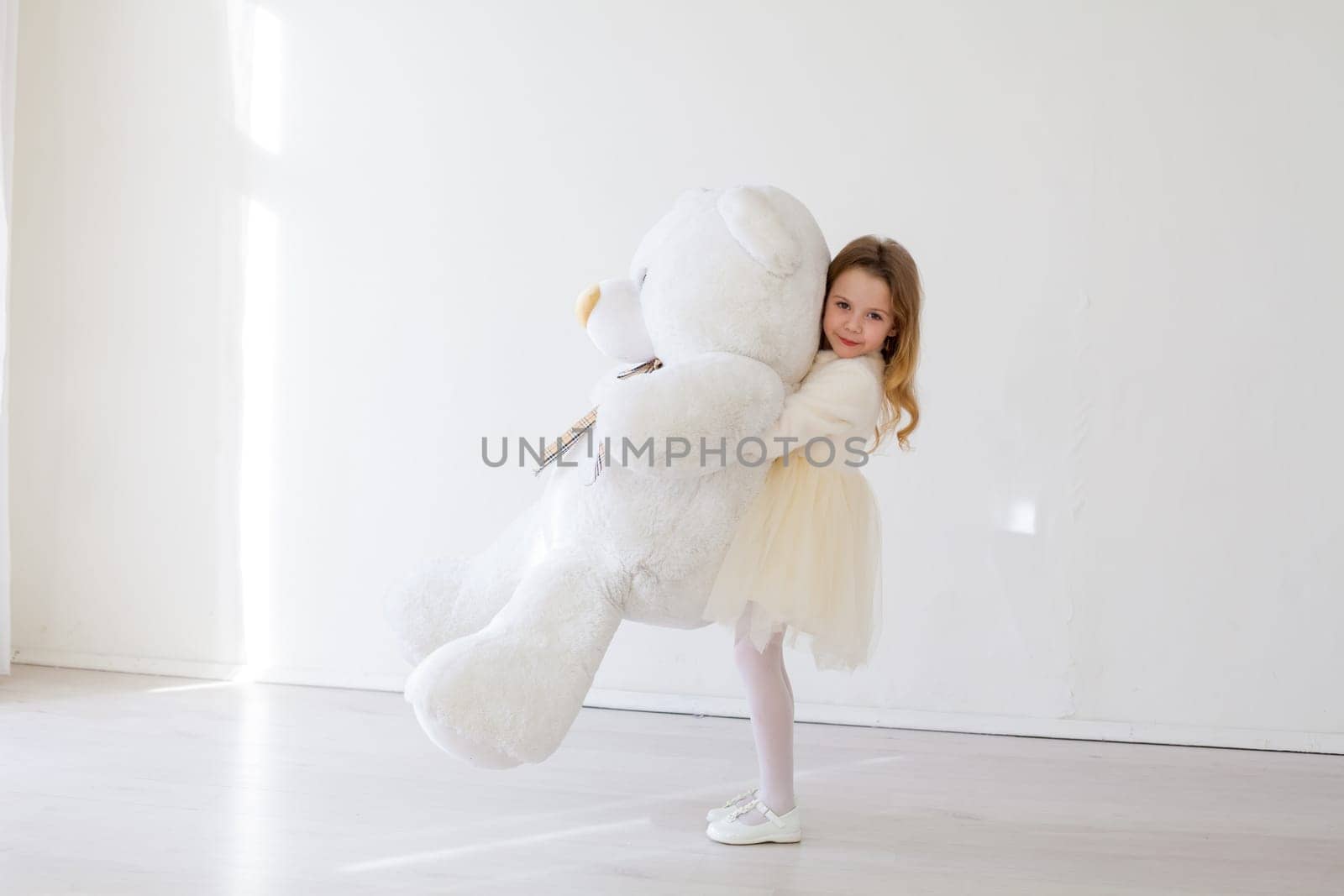 girl holds a large soft toy polar bear