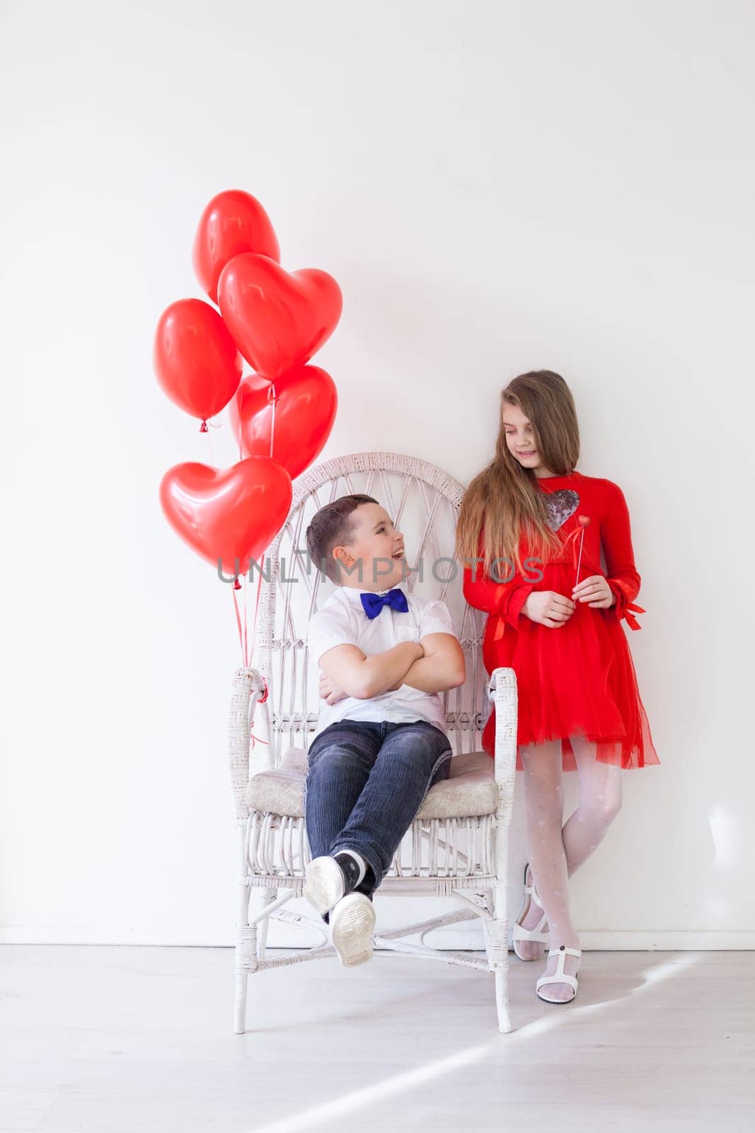 beautiful girl and boy with red balloons in the shape of a heart