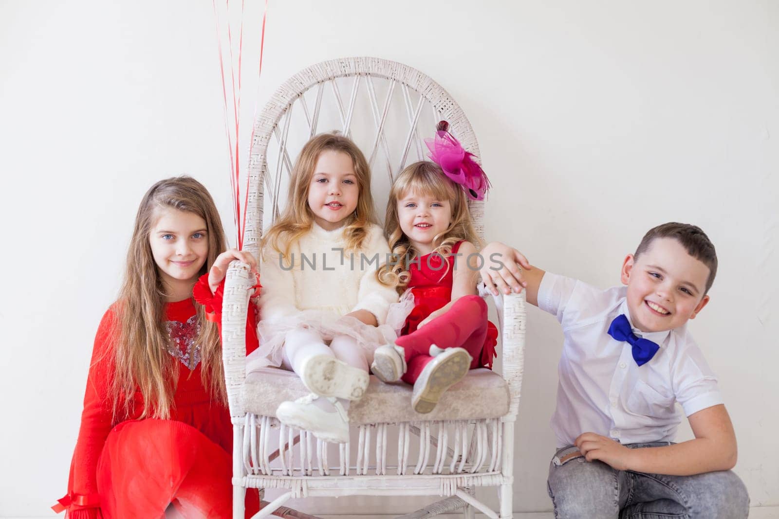 girls and boy in red and white clothes on birthday party by Simakov