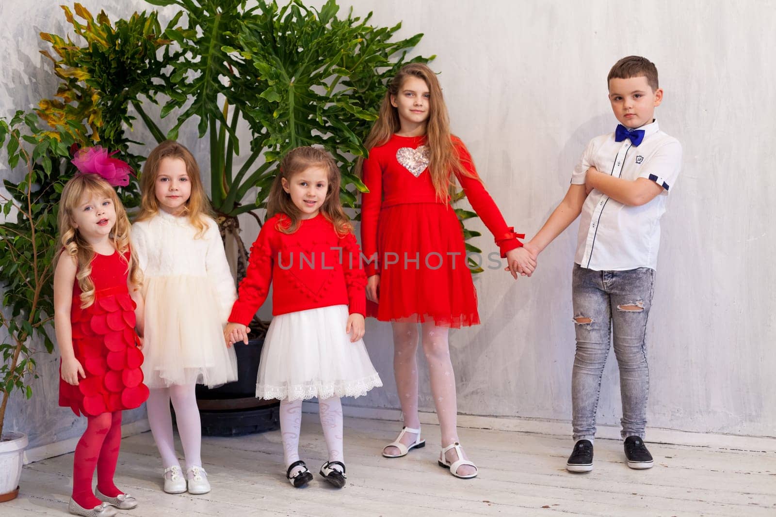 girls and boy in red and white clothes on birthday party by Simakov