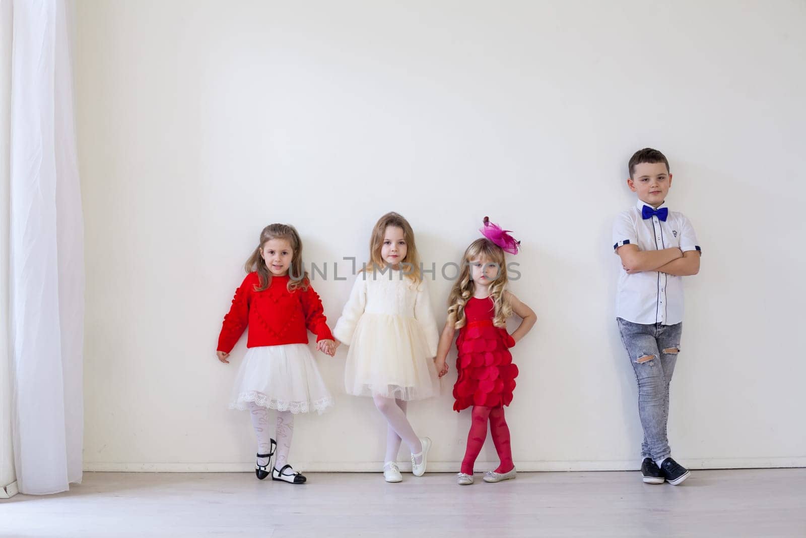 girls and boy in red and white clothes on birthday party by Simakov
