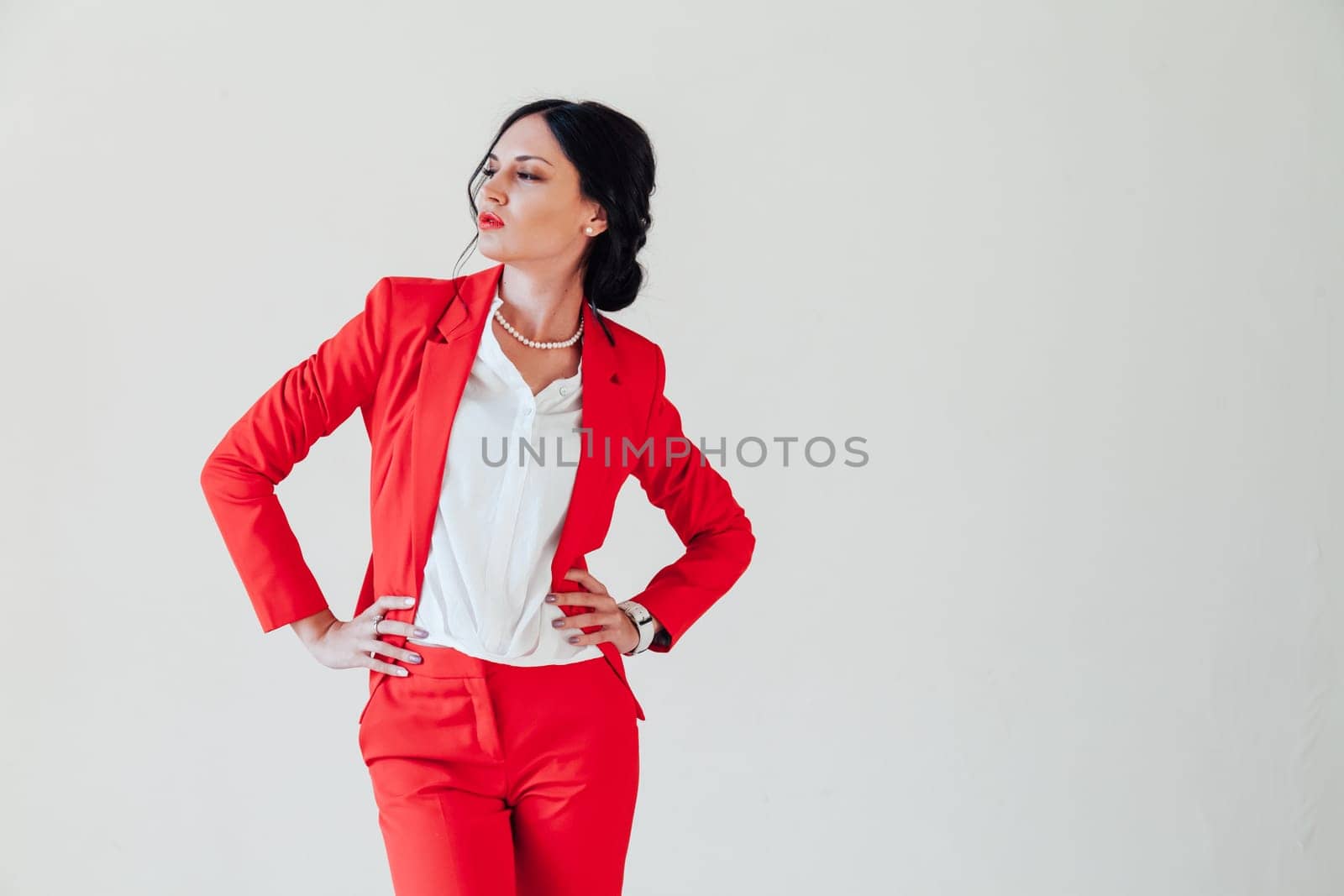 Portrait of a beautiful woman in a red business suit in the office