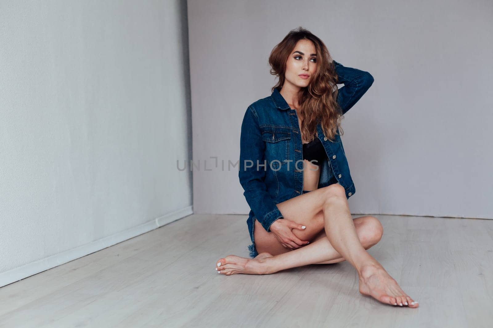 Portrait of a fashionable beautiful woman in denim shorts jacket and lingerie by Simakov