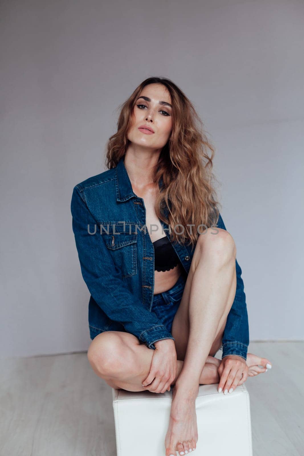 Portrait of a fashionable beautiful woman in denim shorts and lingerie by Simakov