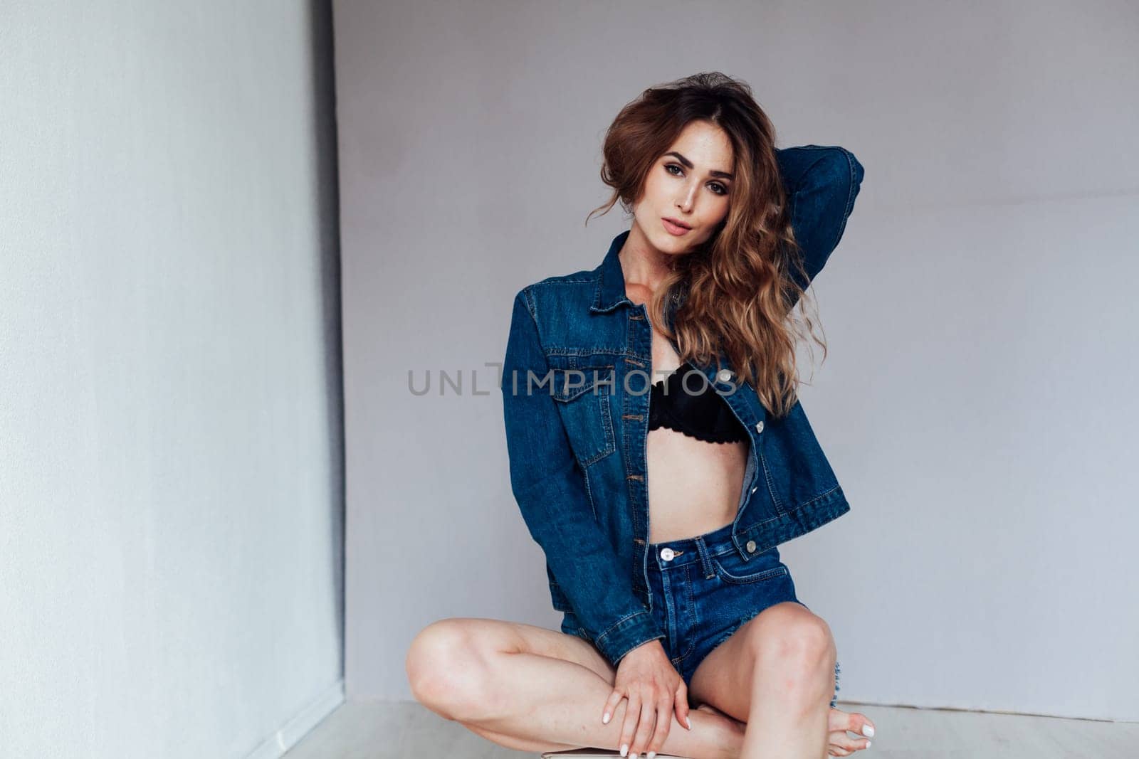 Portrait of a fashionable beautiful woman in denim shorts and lingerie by Simakov