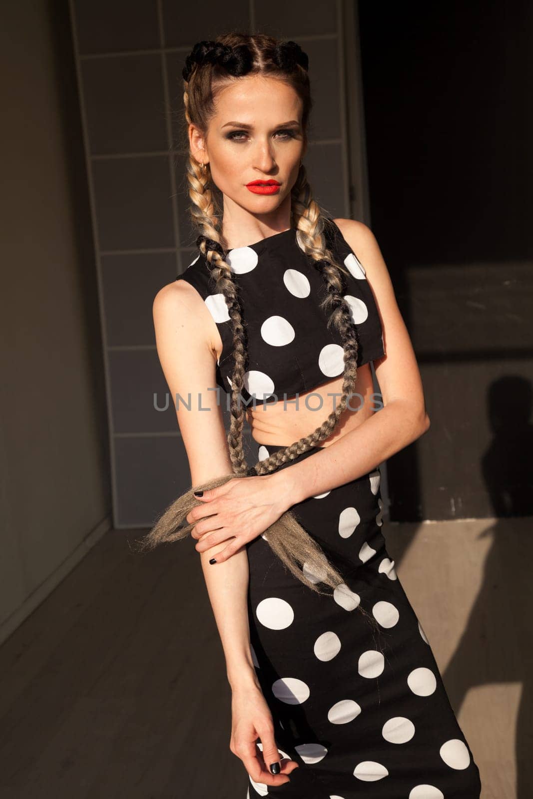 Beautiful fashionable woman braids in polka dot dress by Simakov