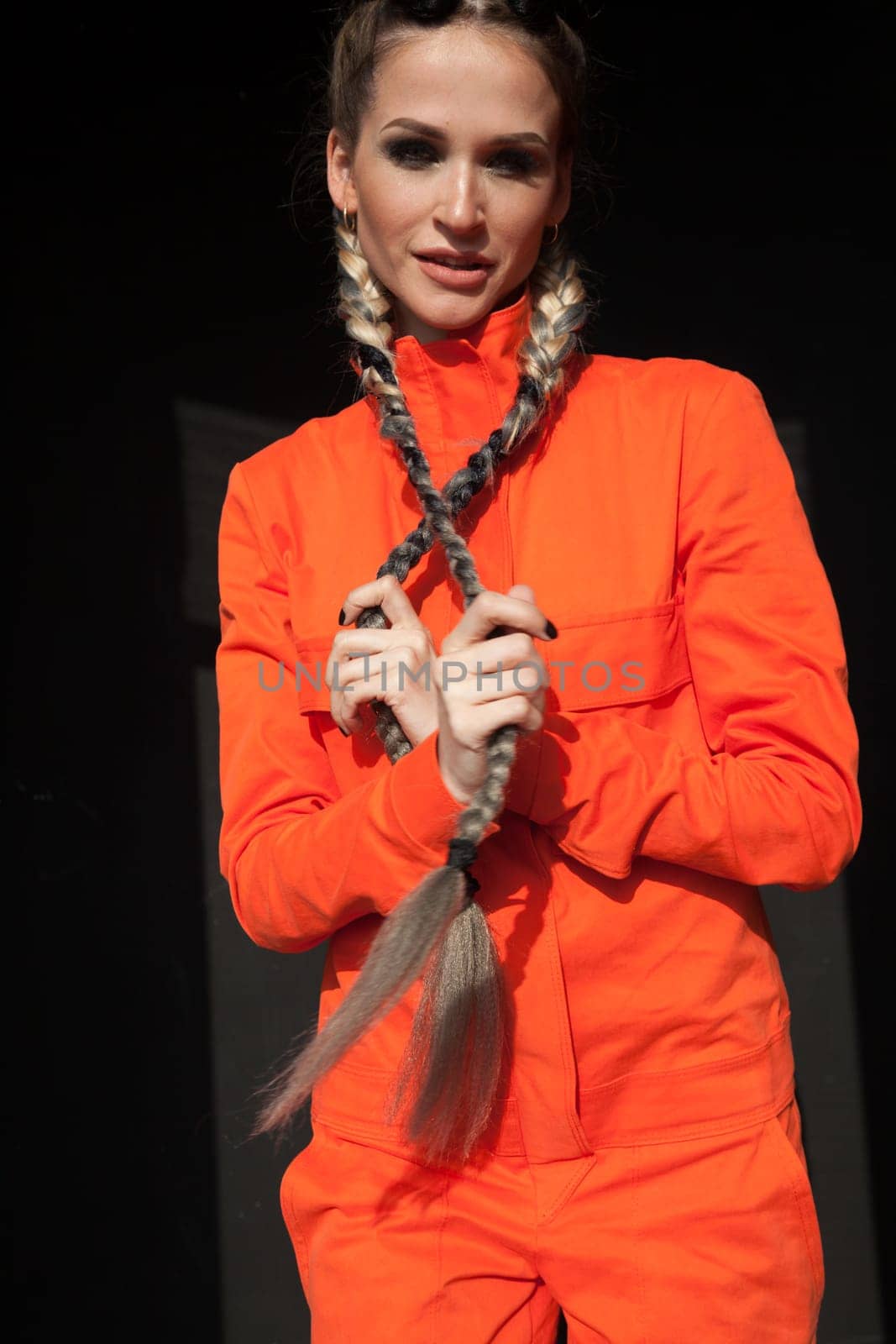 portrait of a beautiful woman with braids in an orange jumpsuit
