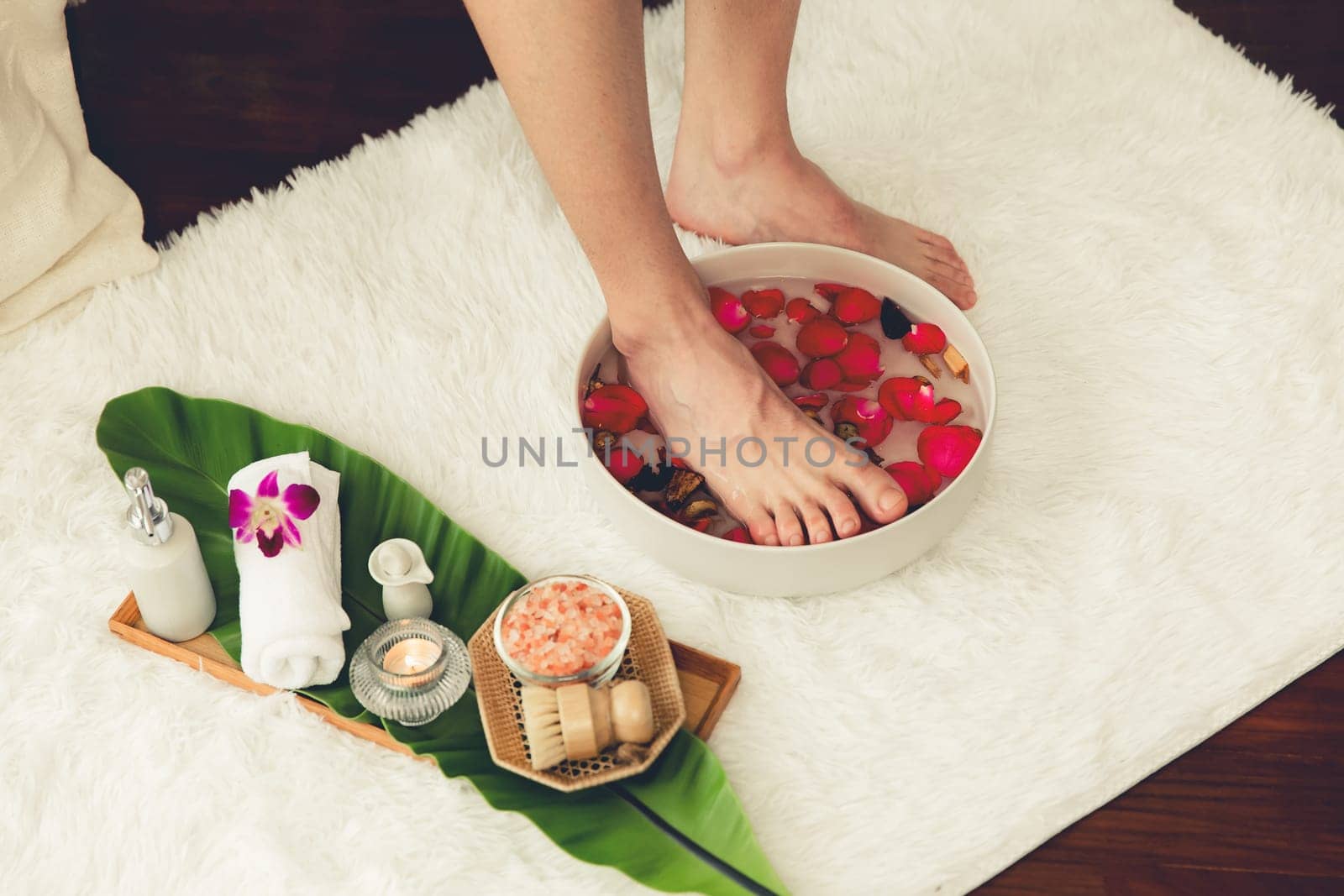 Man indulges in blissful foot massage at luxurious spa salon while masseur give reflexology therapy in gentle day light ambiance resort or hotel foot spa. Quiescent