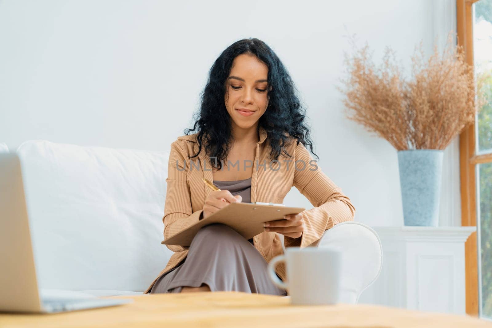 African-American woman using laptop computer for crucial work on internet. Secretary or online content writing working at home.