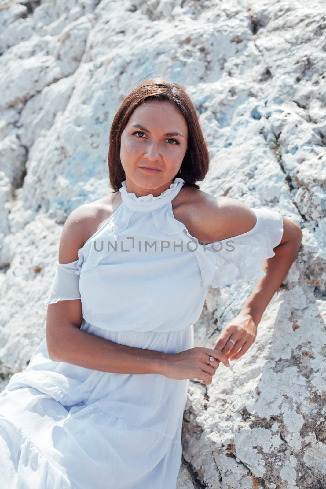 portrait of a beautiful woman with long hair in a dress on a cliff cliff by the sea by Simakov